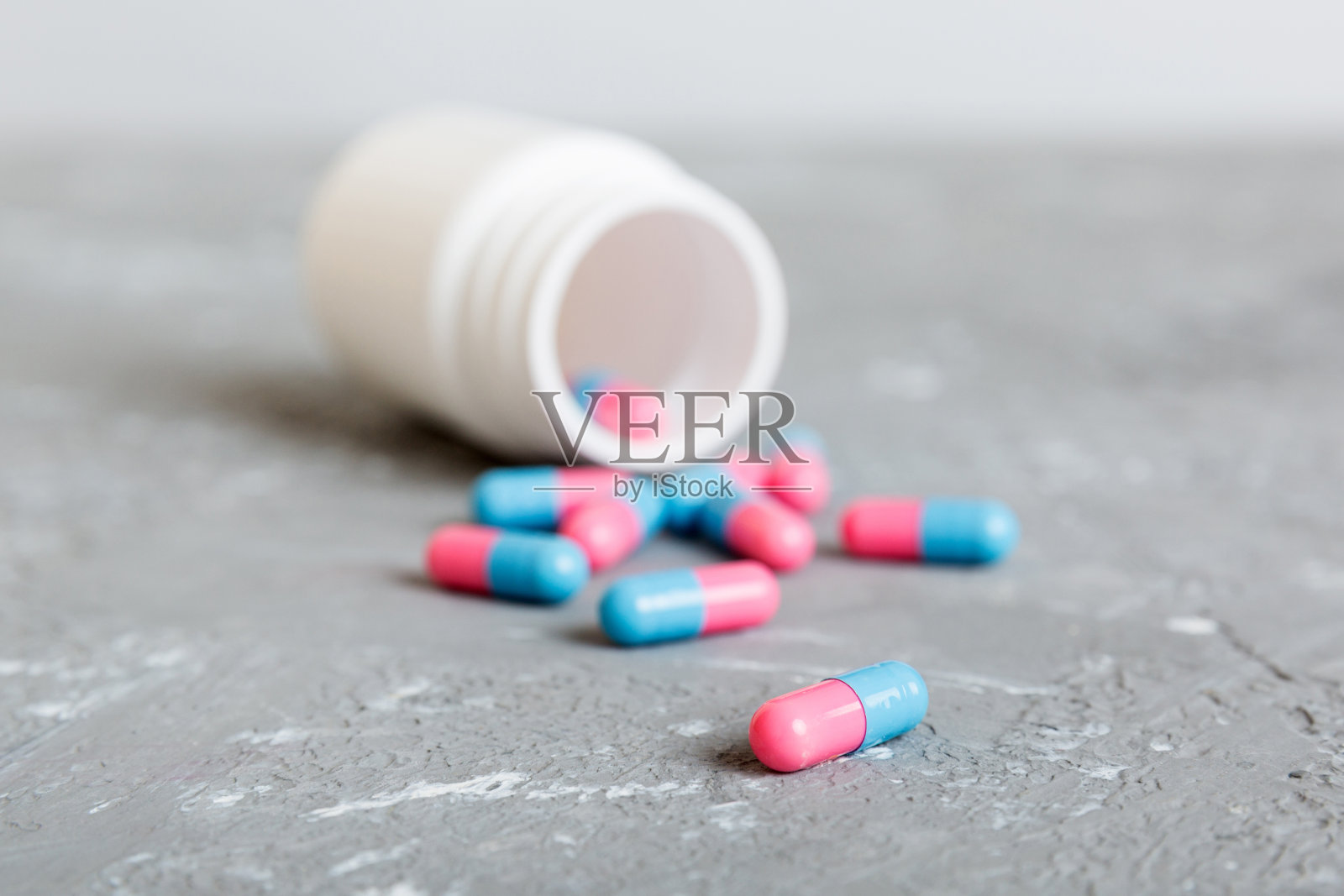 彩色背景上有胶囊的塑料药瓶。网上药店。止痛药和抗生素耐药性的概念。制药行业照片摄影图片