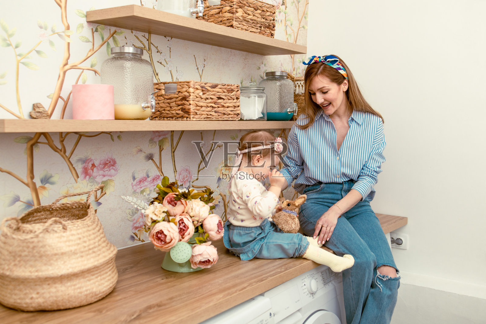 妈妈给女儿看兔子玩具。东部照片摄影图片