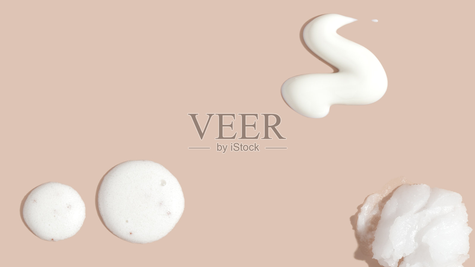 各种化妆品磨砂膏,面霜,精华液和乳液涂抹在粉红色的背景组成。美丽纹理。化妆品样品。照片摄影图片