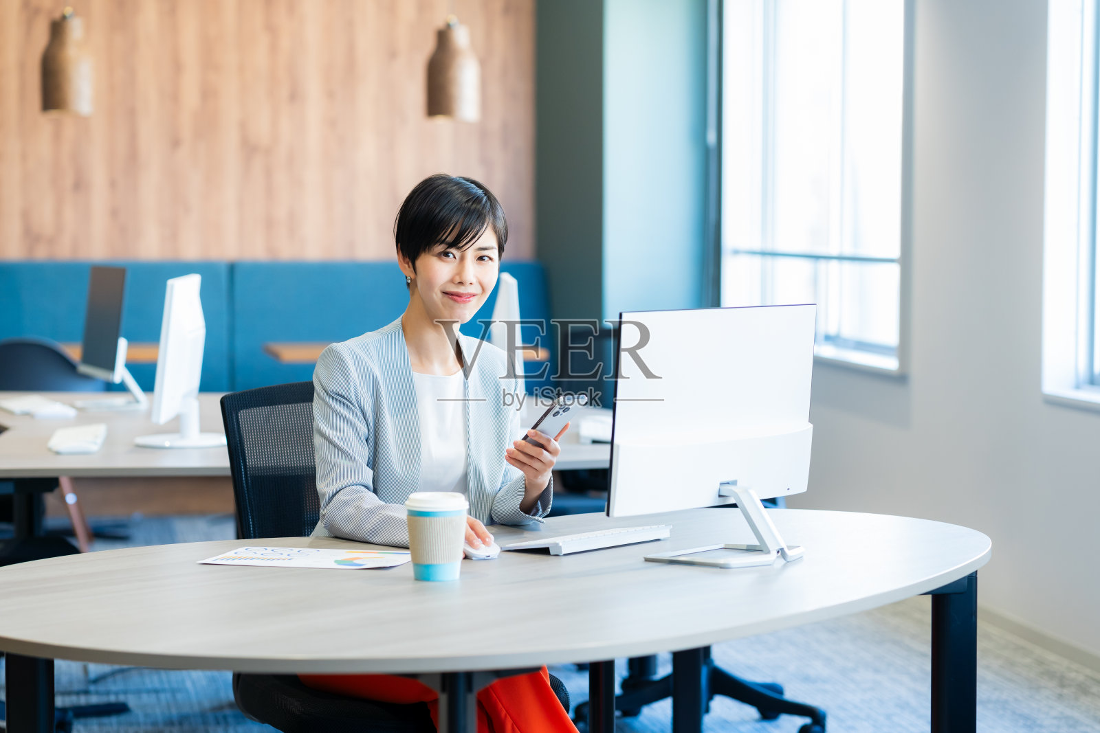 办公室里有智能手机的女商人照片摄影图片