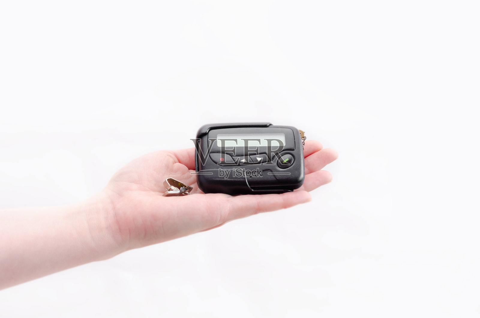 特写中的传呼机,一个老式的通讯设备,在白色背景的女性手中照片摄影图片