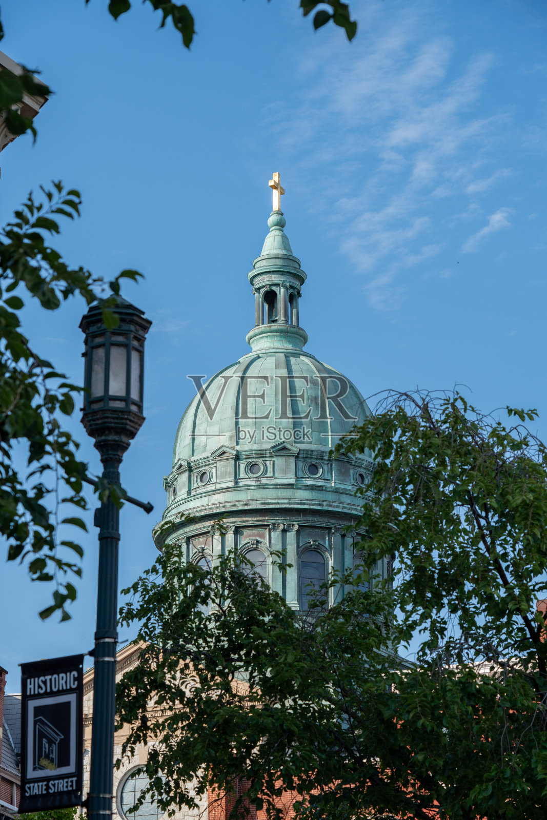 一盏城市路灯,背景是一座建筑,树木在生长照片摄影图片