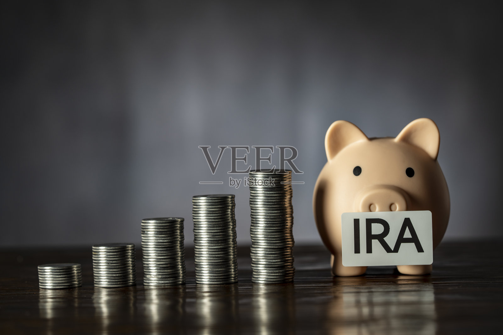 储蓄罐和IRA退休基金的票据。黑色背景上的储蓄罐和钱塔,特写,复制空间。金融、商业、投资和省钱的理念照片摄影图片