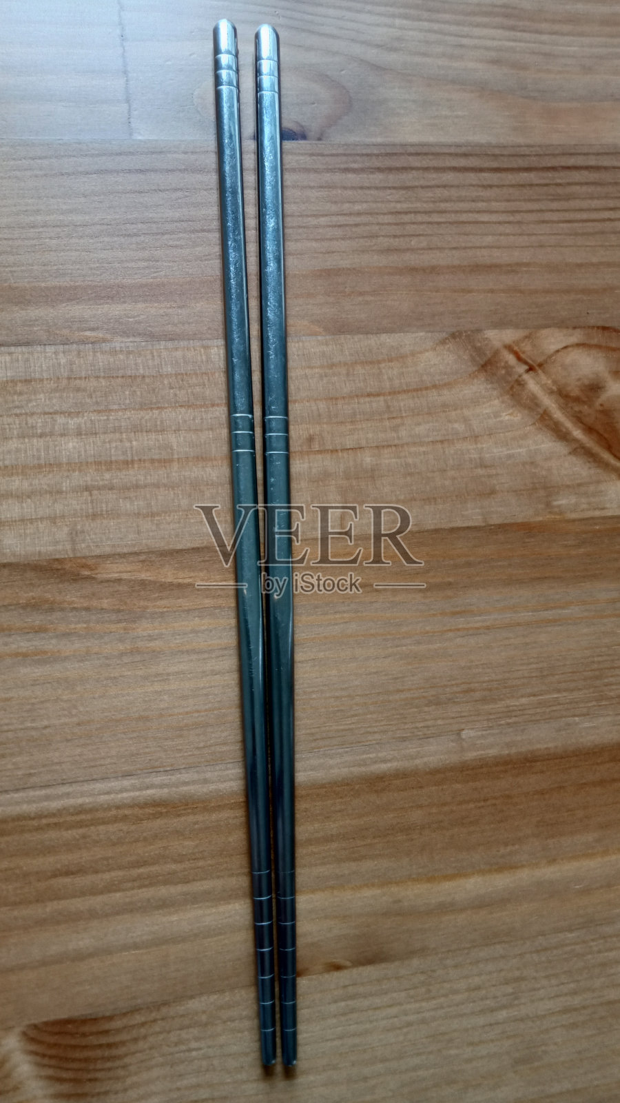 筷子是用来夹起食物,然后放进嘴里的。照片摄影图片