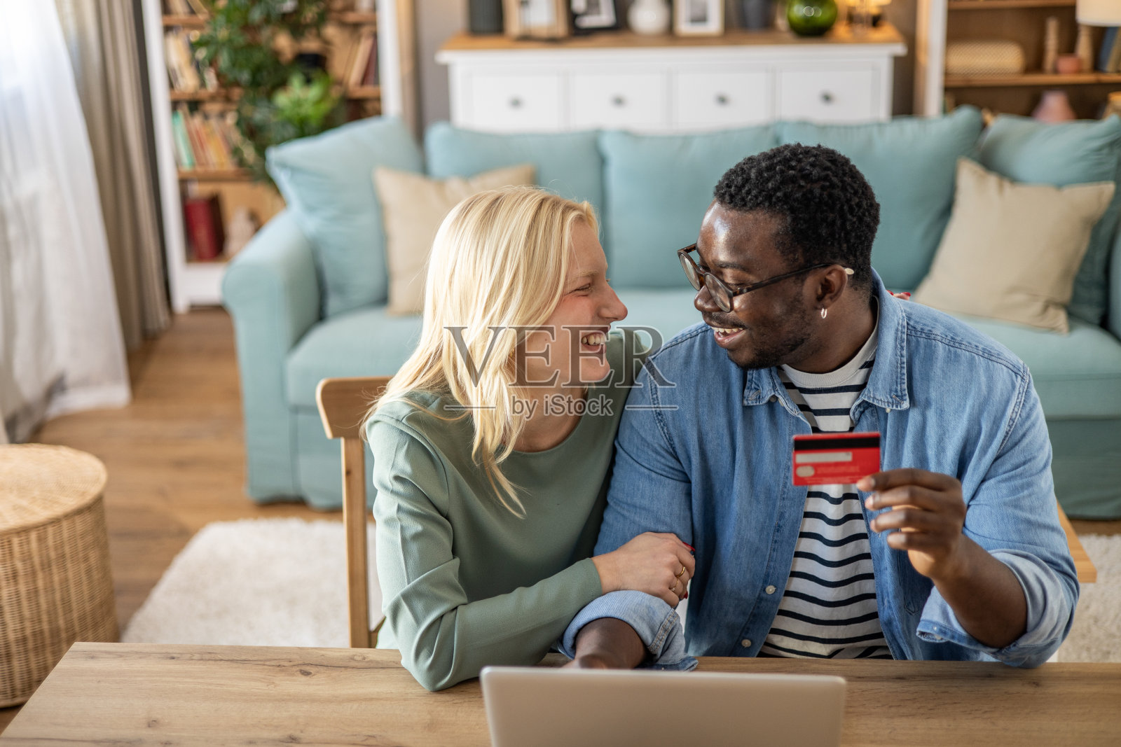 一对年轻的混血夫妇,一个黑人男人和一个白人女人,正在网上购物照片摄影图片