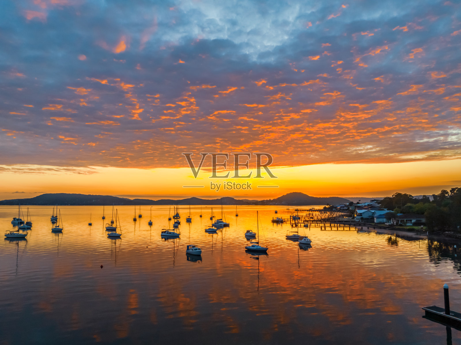 空中日出,水面上有船和云照片摄影图片