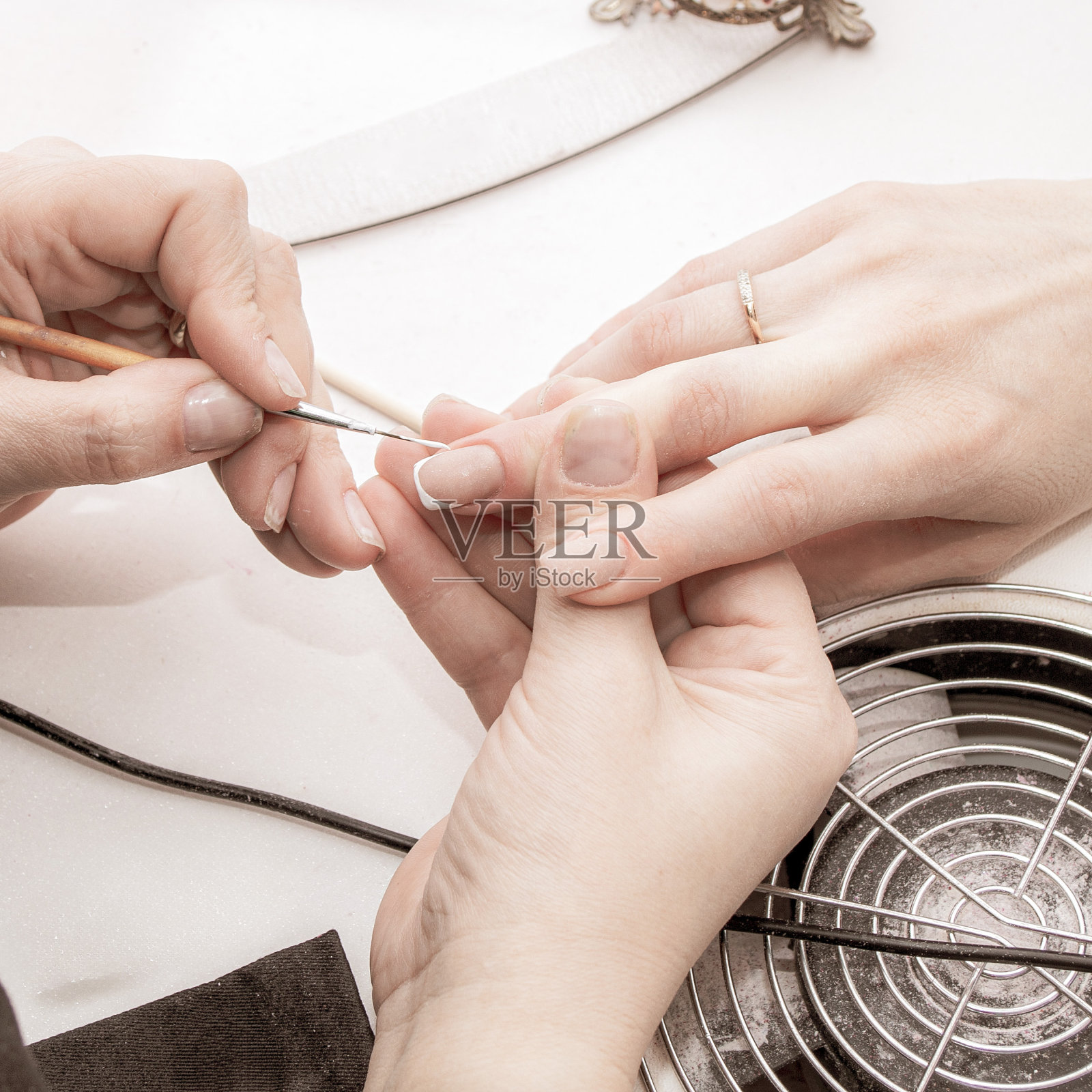 美甲师正在给一位女客户打理指甲,整理指甲,让指甲保持健康,特写照片照片摄影图片