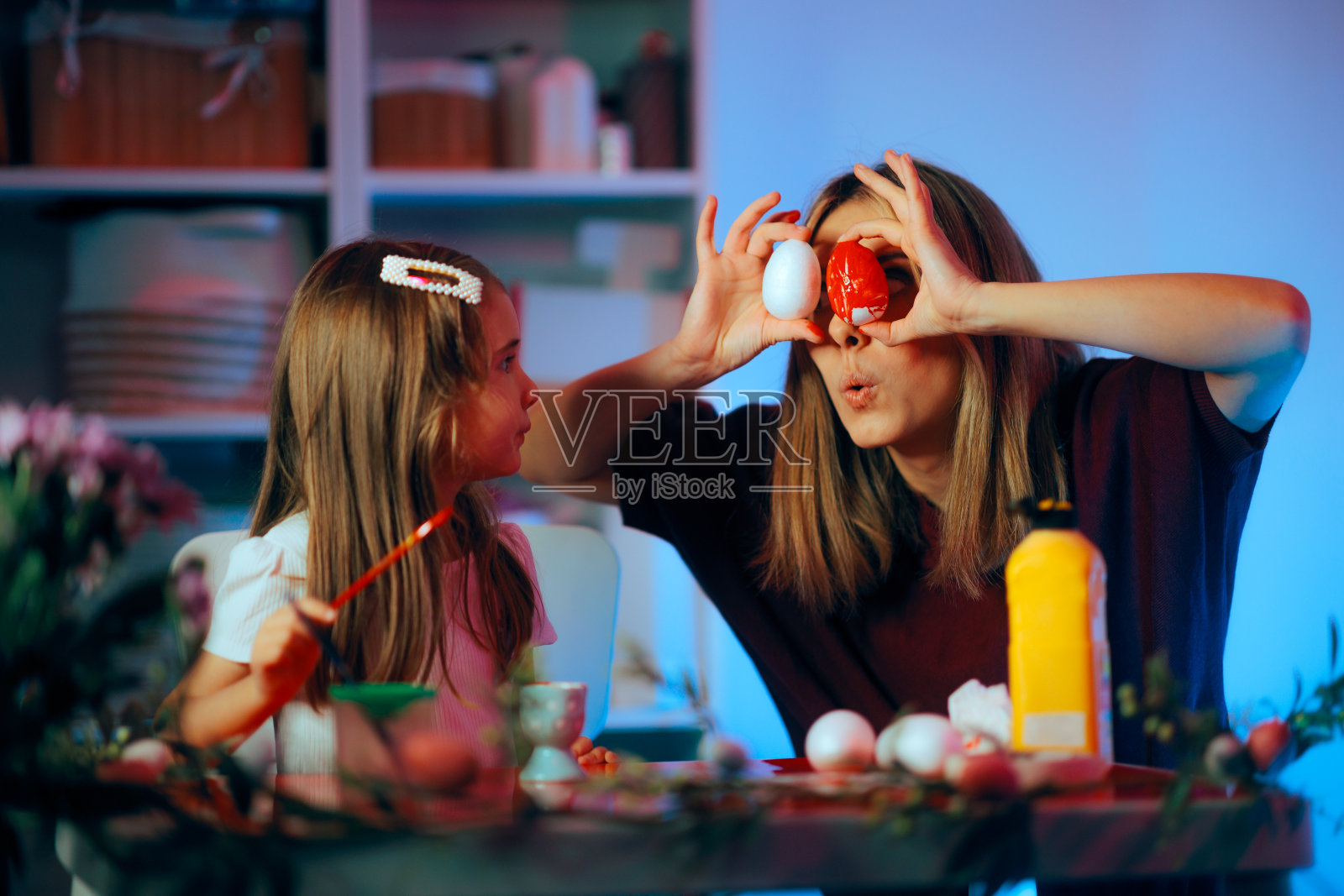 有趣的妈妈逗她的女儿复活节彩蛋的眼睛照片摄影图片