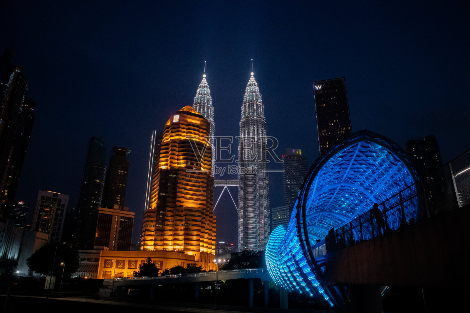 马来西亚国家石油公司双子塔和萨洛玛大桥,吉隆坡的重要标志。周围有美丽的风景。夜间的建筑物照片摄影图片