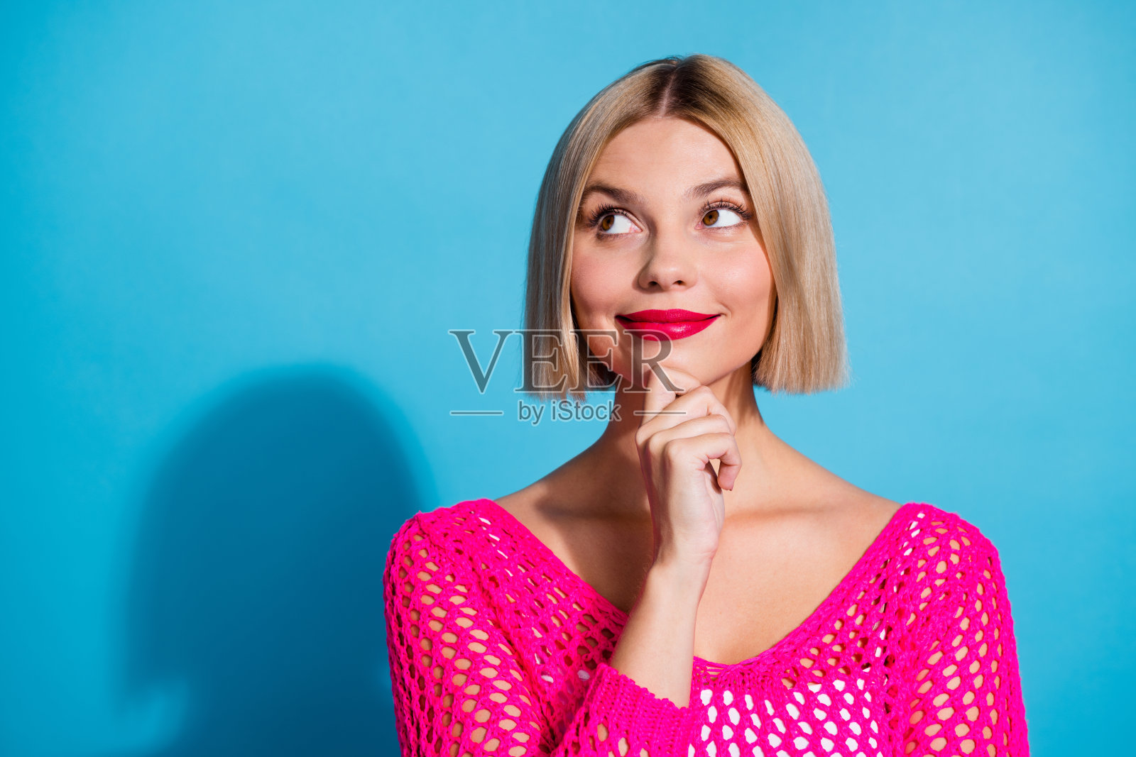 可爱的年轻女士的照片肖像看起来感兴趣的空白空间穿时髦的粉红色针织服装孤立的蓝色背景照片摄影图片