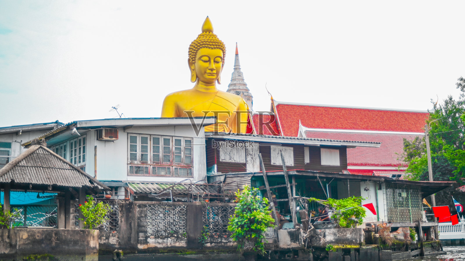 从远处的运河上看到的一尊巨大的佛像,靠近泰国的白南寺照片摄影图片