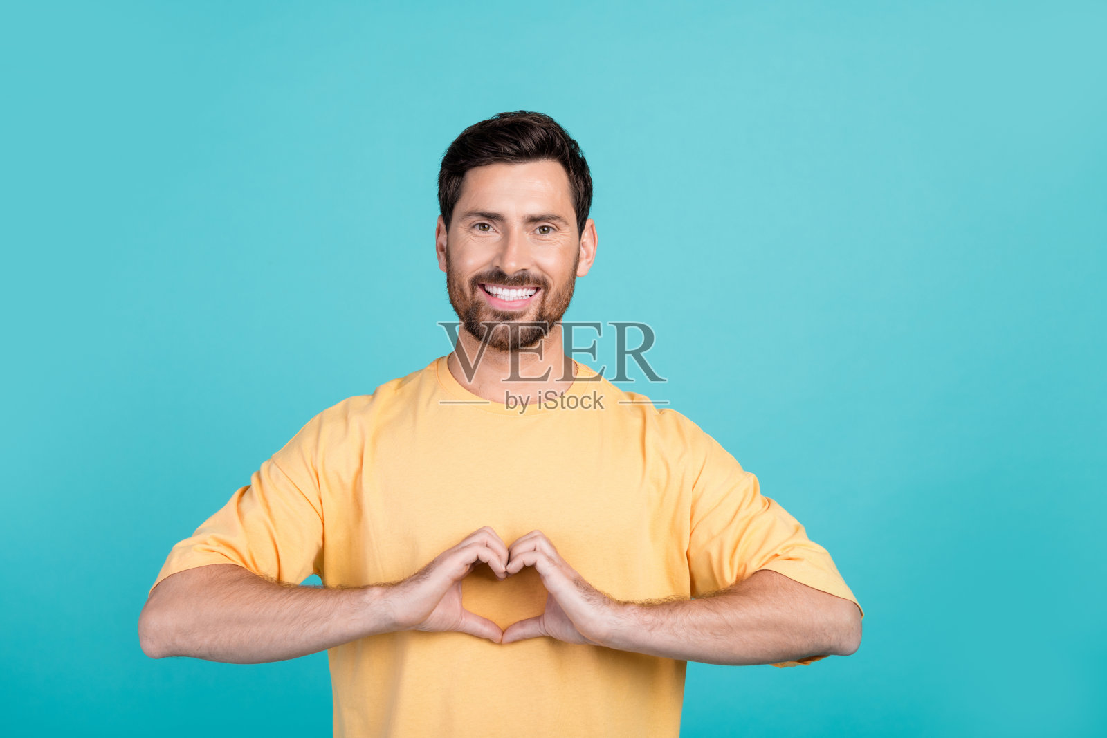 年轻乐观的男友在青色背景下录制视频,祝贺女友情人节快乐照片摄影图片