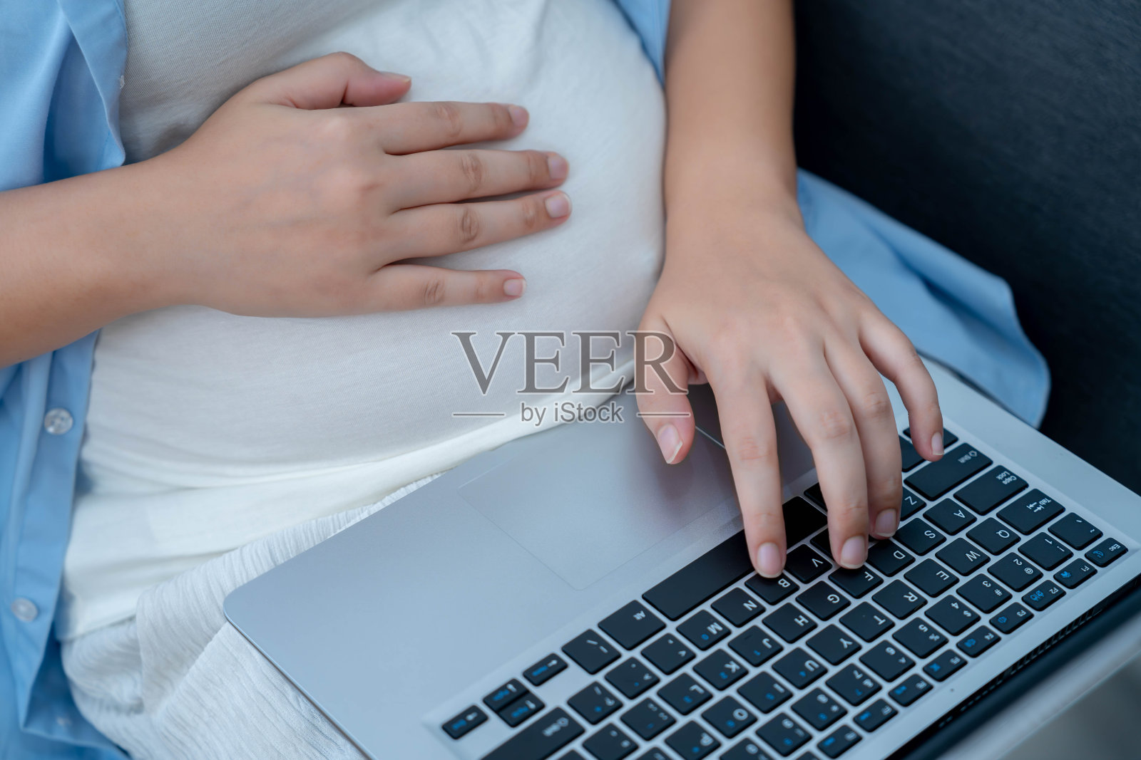 孕妇在客厅使用笔记本电脑查找产前护理年轻的亚洲孕妇上网,远程工作,为新生儿购买商品照片摄影图片