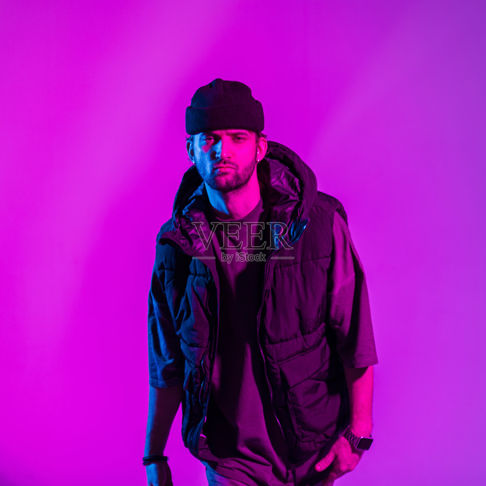 时尚的职业舞者,穿着时尚的帽子,背心和t恤,在粉红色和霓虹灯的彩色工作室照片摄影图片