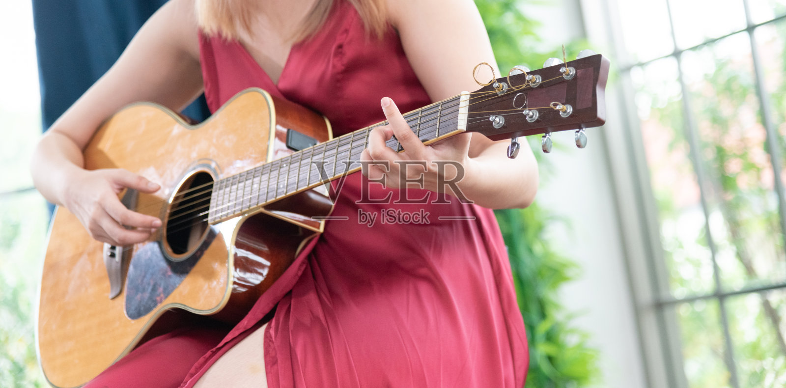 年轻漂亮的亚洲女人弹原声吉他。时尚的生活方式照片摄影图片