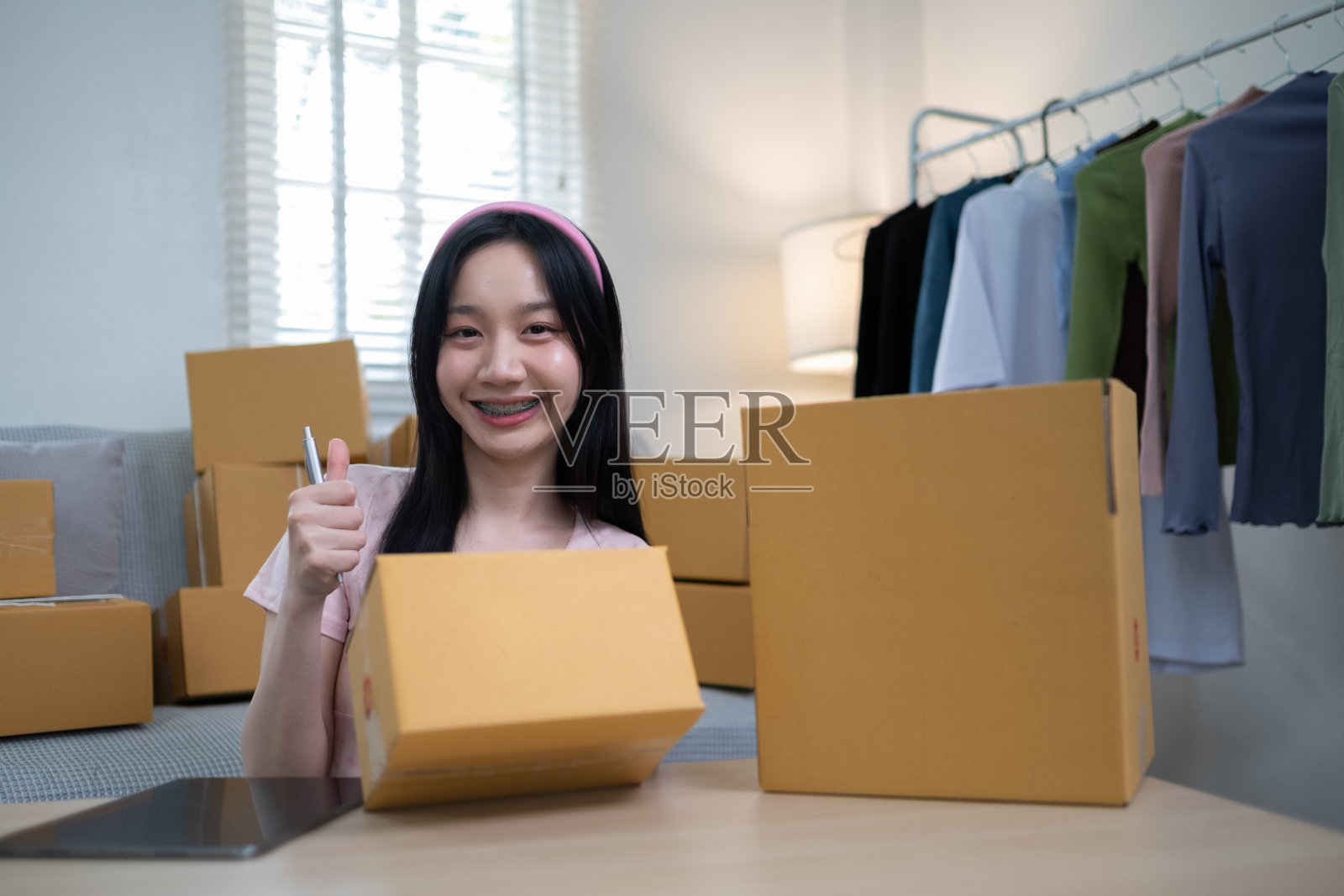 年轻的网上创业中小企业美女亚洲女工作写盒子准备送货给客户,航运购物网上,SMW工作与盒子在家里照片摄影图片