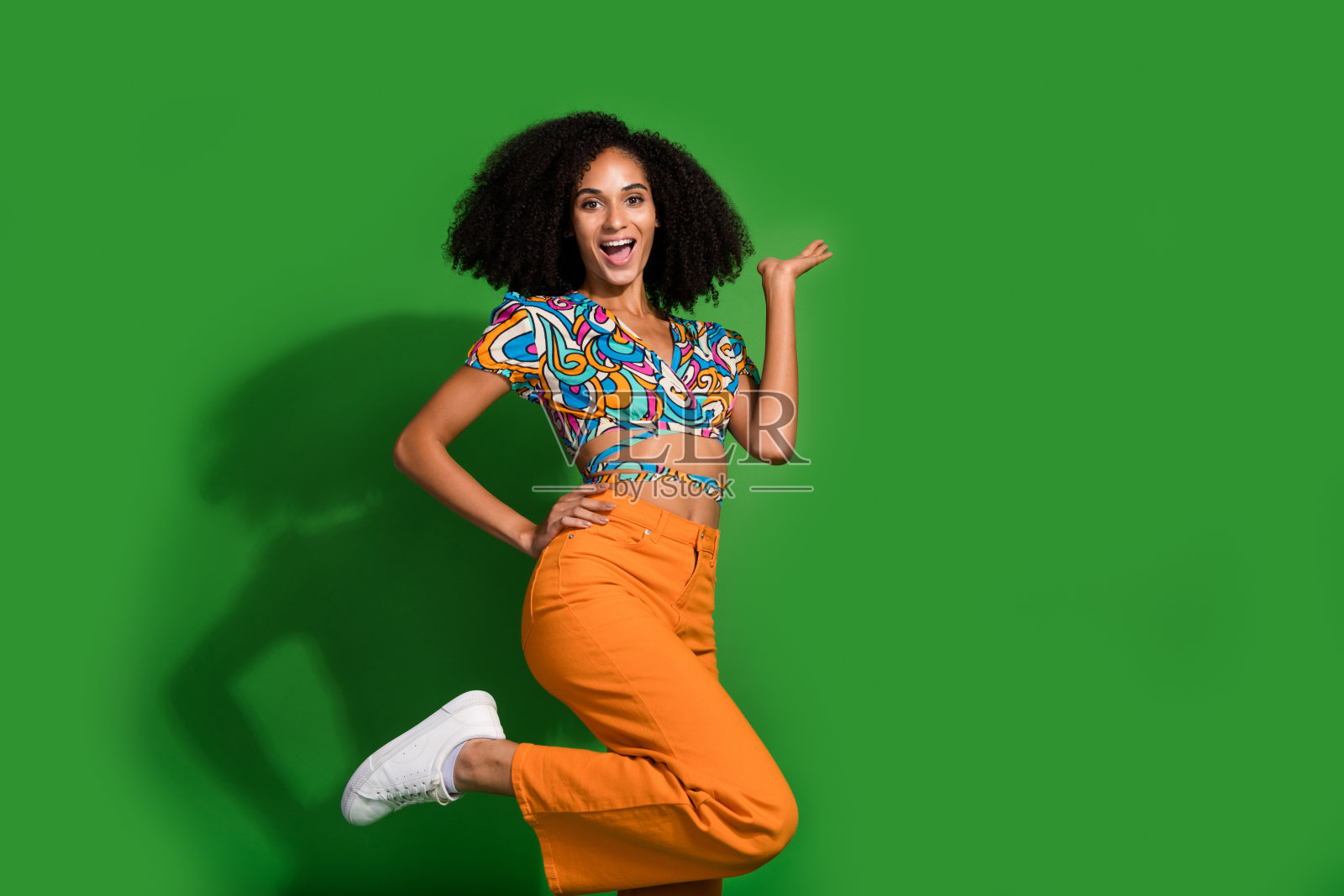 有趣的美国女孩在时尚的顶部拿着手掌展示新的鸡尾酒吧菜单copyspace孤立的绿色背景的照片照片摄影图片