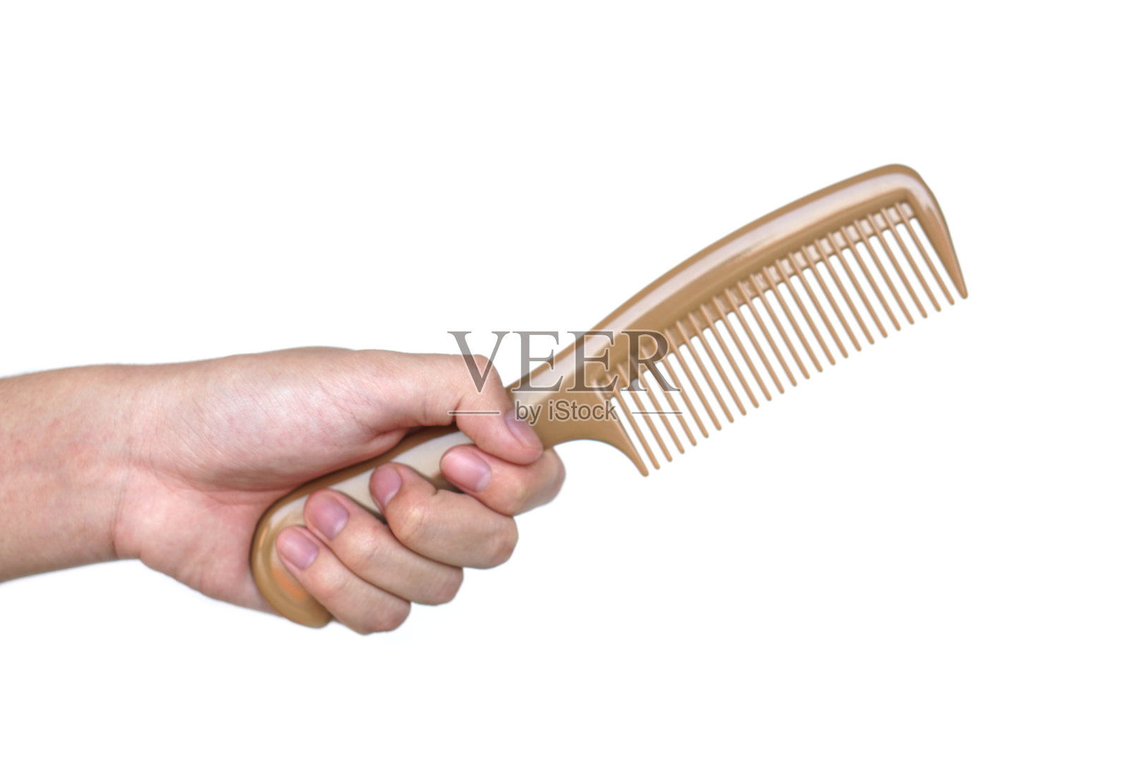 近距离手持棕色梳子隔离在白色背景。理念,日常生活中发型设计的美发美容工具。护发设备。照片摄影图片