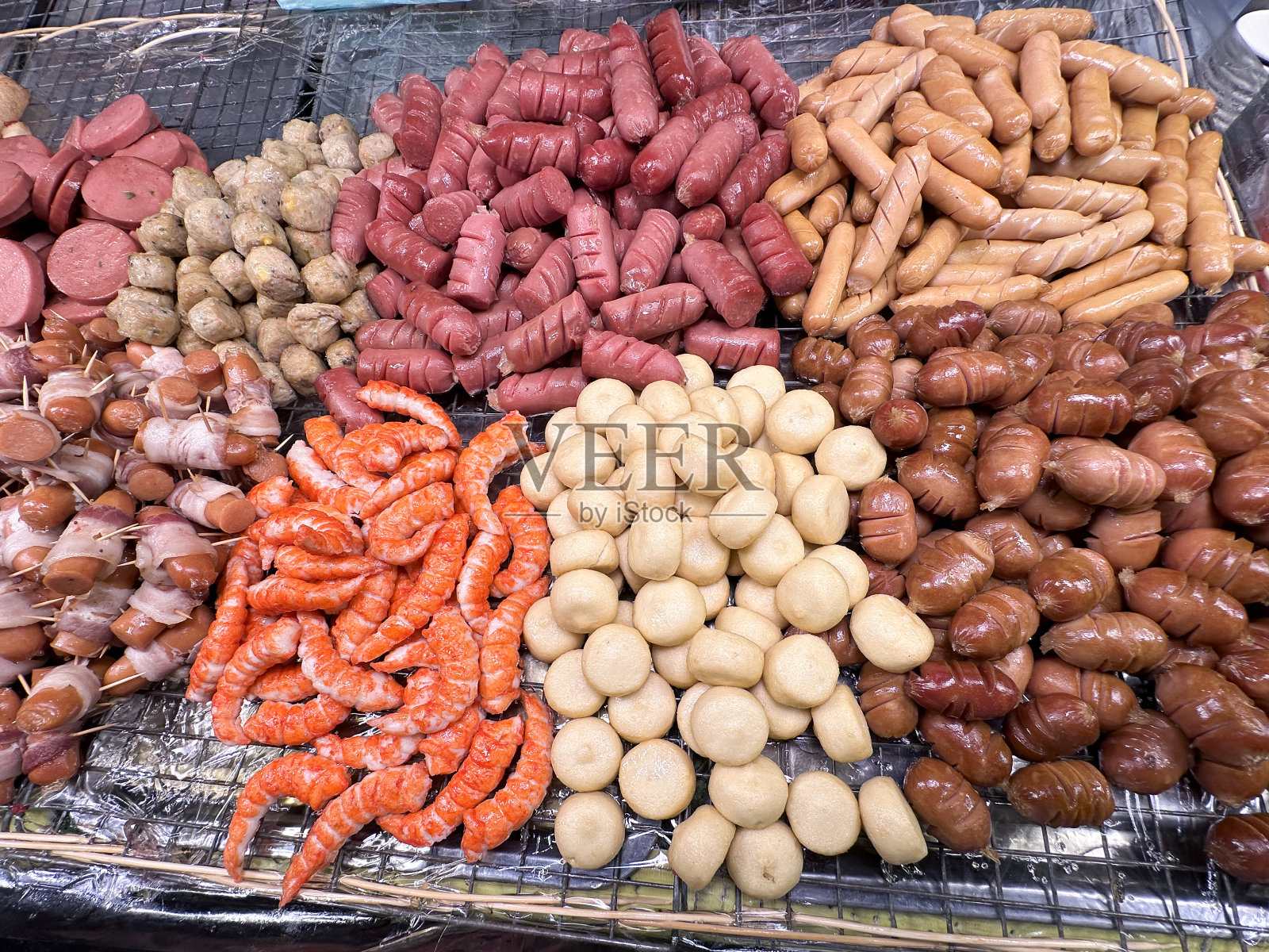 屠夫托盘展示的图像,一堆煮熟的,切片的法兰克福香肠,裹在毯子里的猪(用培根包裹的鸡尾酒香肠)和虾,准备吃零食,抬高视图照片摄影图片