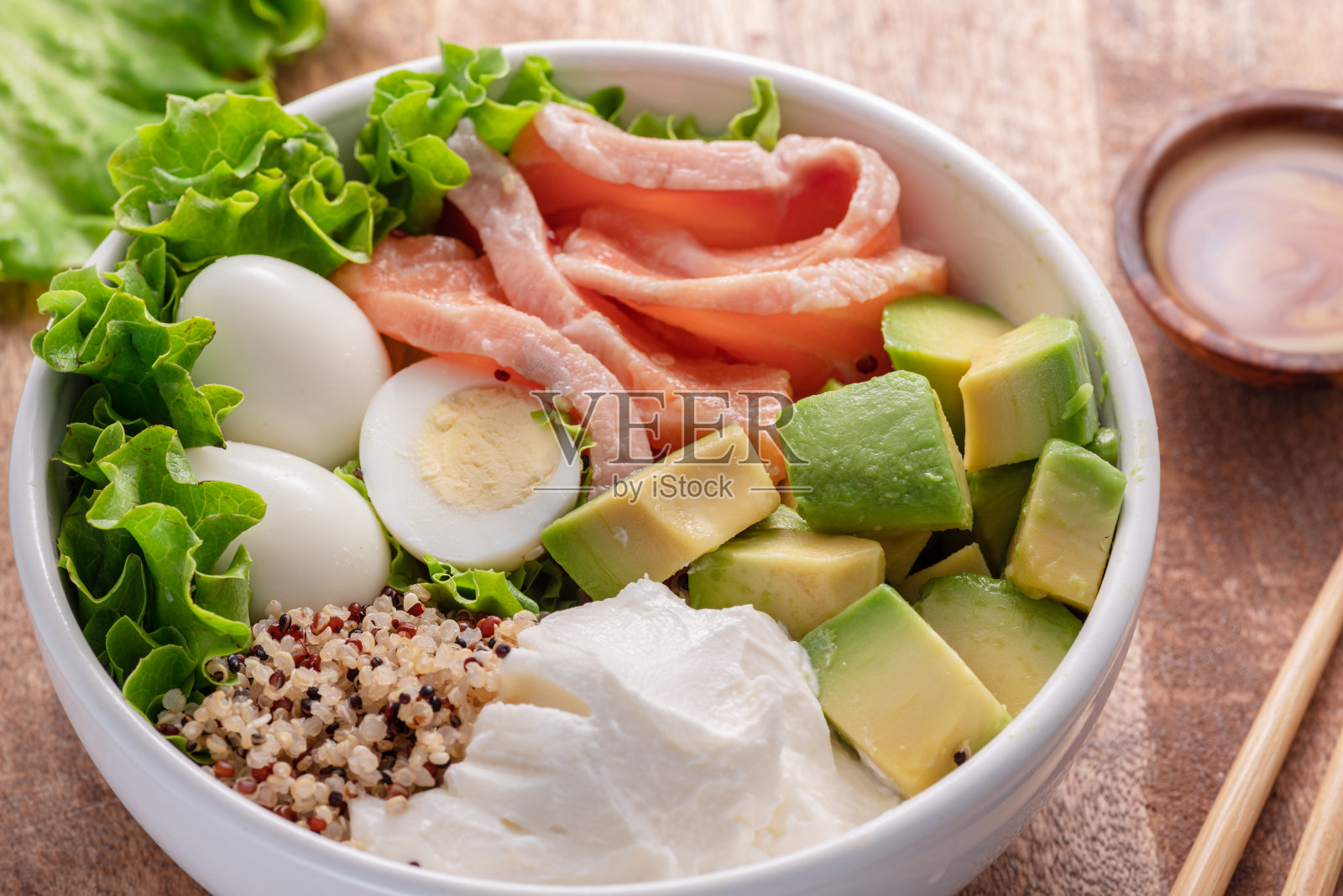 木桌上的蔬菜三文鱼藜麦碗。平衡膳食,顶视图照片摄影图片