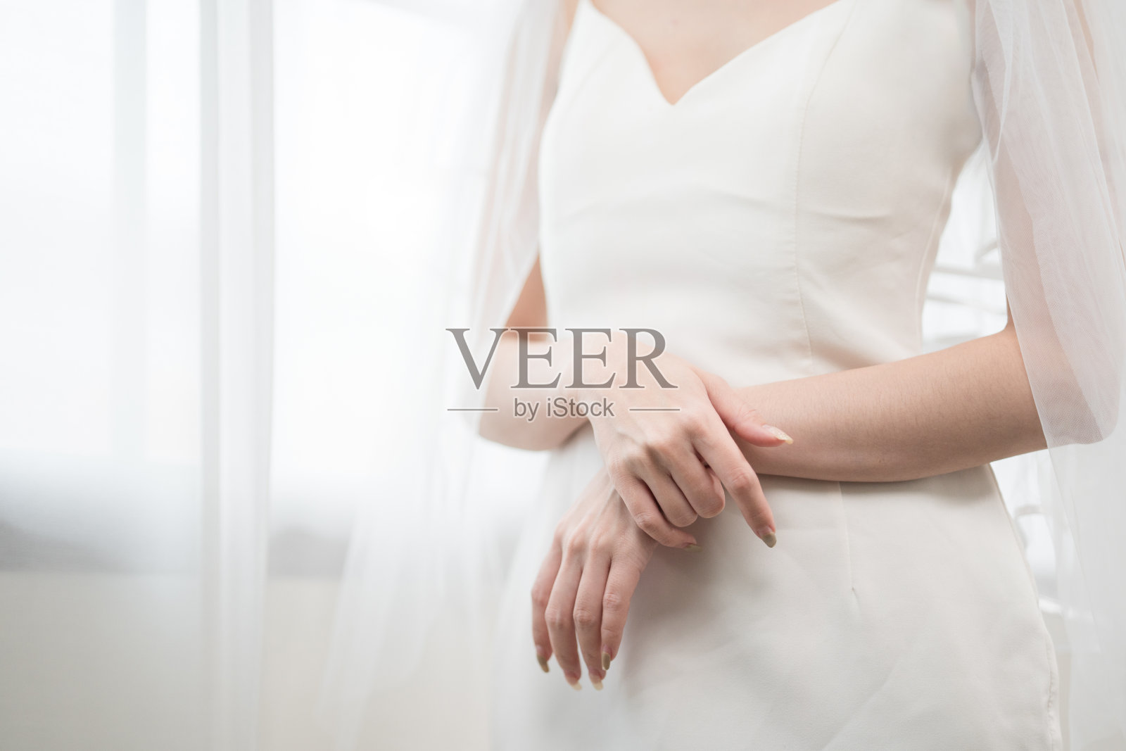 美丽的亚洲新娘与时尚的婚礼发型和化妆。年轻美丽的新娘的肖像在白色的房间里拍摄的婚礼工作室。照片摄影图片