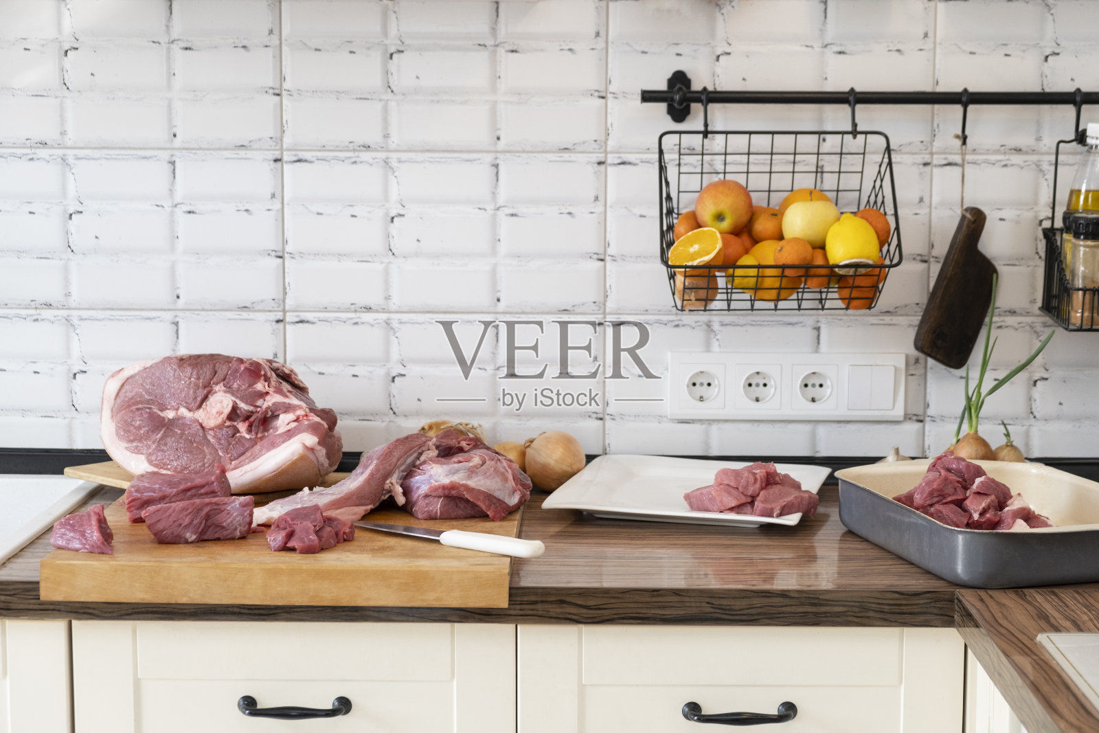 不同种类的肉。班纳在船上的白色厨房里切新鲜的生肉。准备猪肉,烹饪照片摄影图片