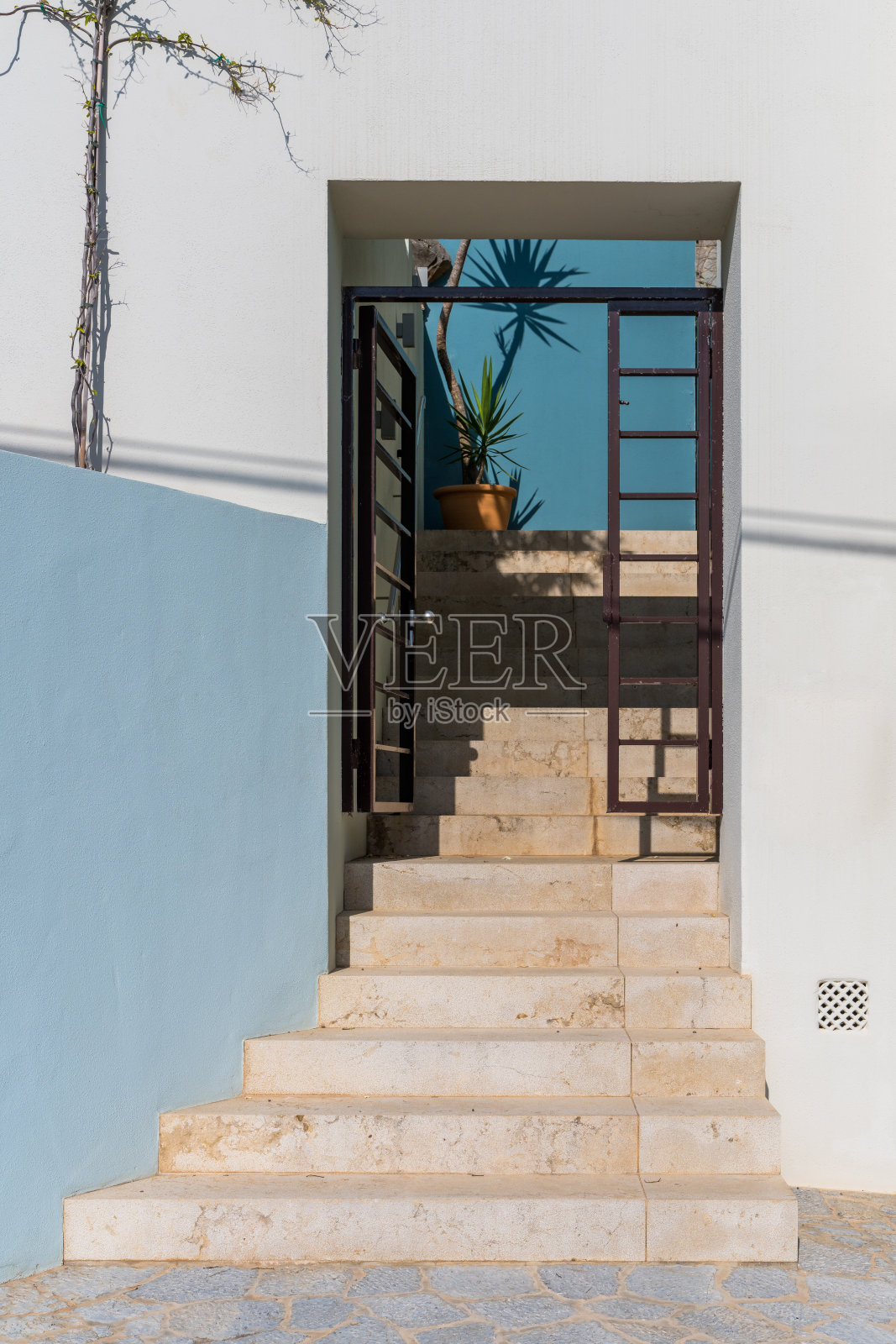 石阶楼梯通向一座小房子,远处有一棵棕榈树。巴利阿里群岛,马略卡岛照片摄影图片