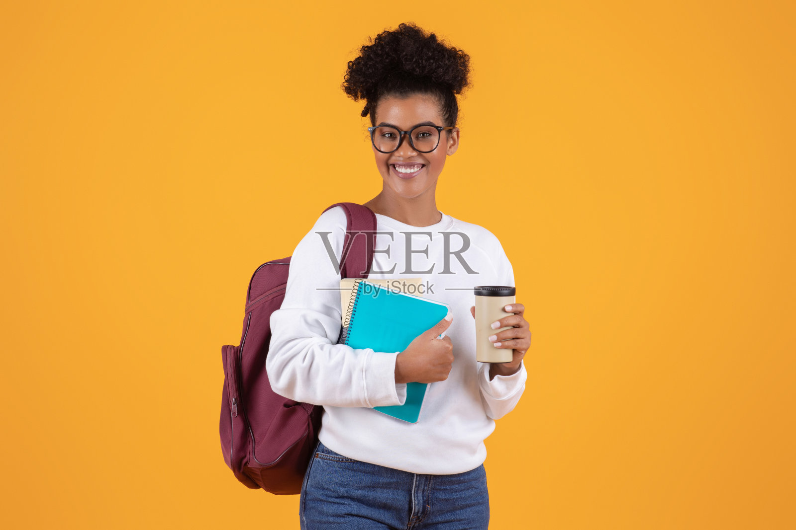 黑人女学生戴着眼镜背着背包拿着笔记本和外卖咖啡照片摄影图片