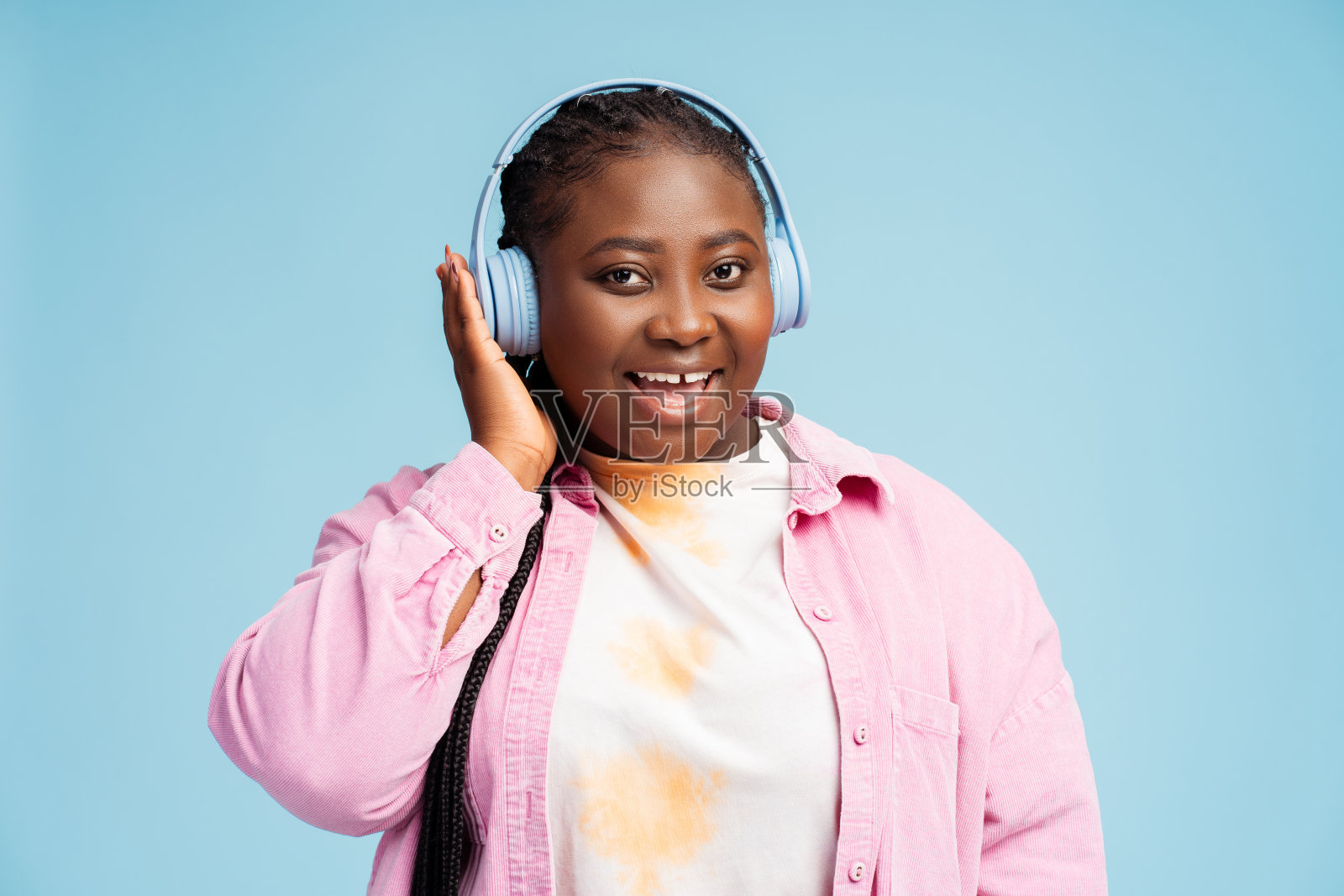 美丽的非裔美国女人戴着无线耳机听着音乐看着相机照片摄影图片