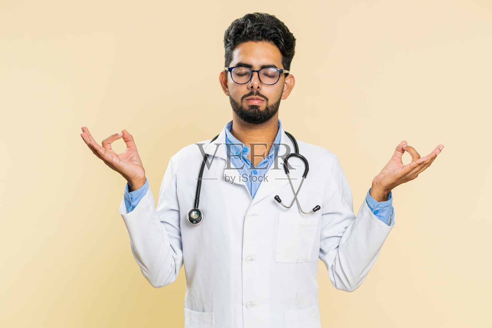 男医生冥想,用手印瑜伽的姿势深呼吸,闭上眼睛,休息,放松照片摄影图片