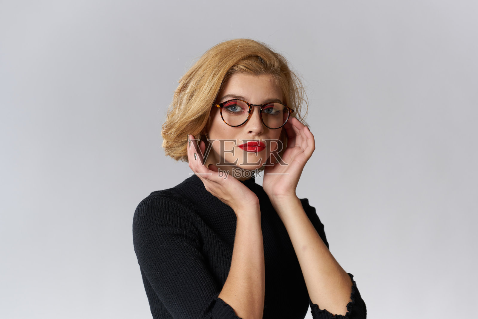金发女孩,戴眼镜,红唇,黑色衬衫,短视图魅力光背景工作室照片摄影图片