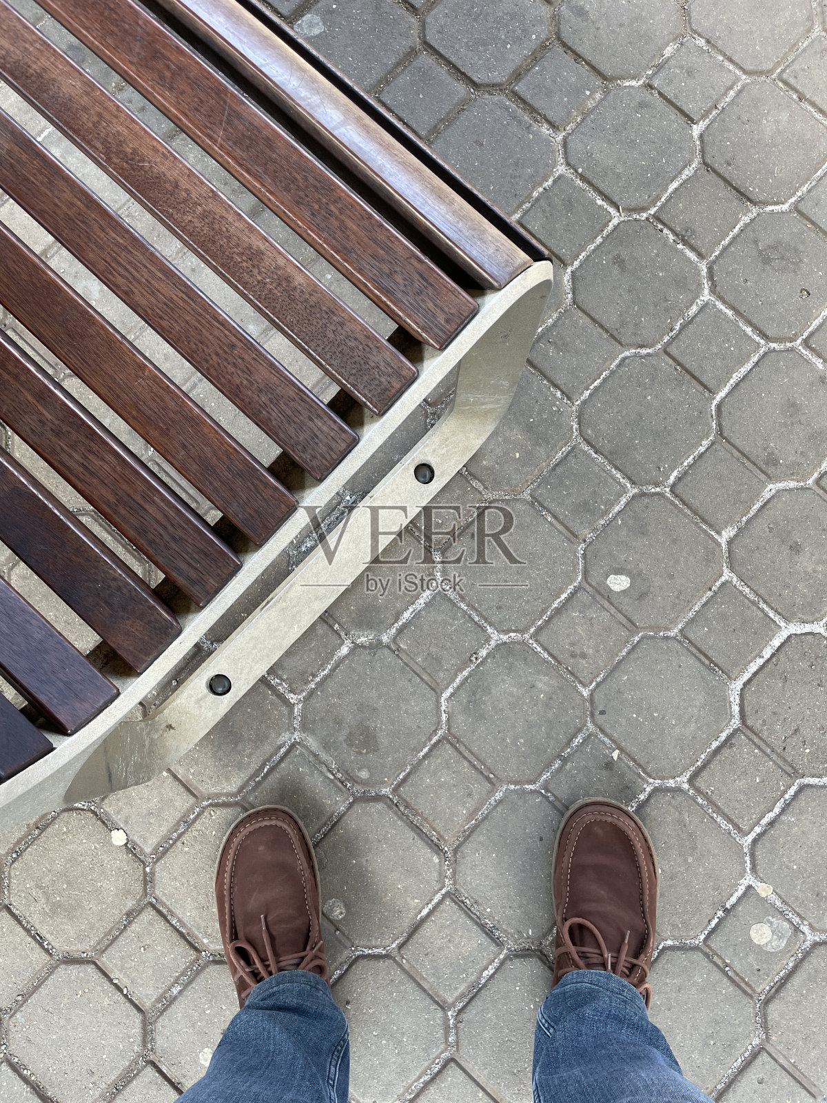 脚踩在鹅卵石上。脚靠近长凳。照片摄影图片