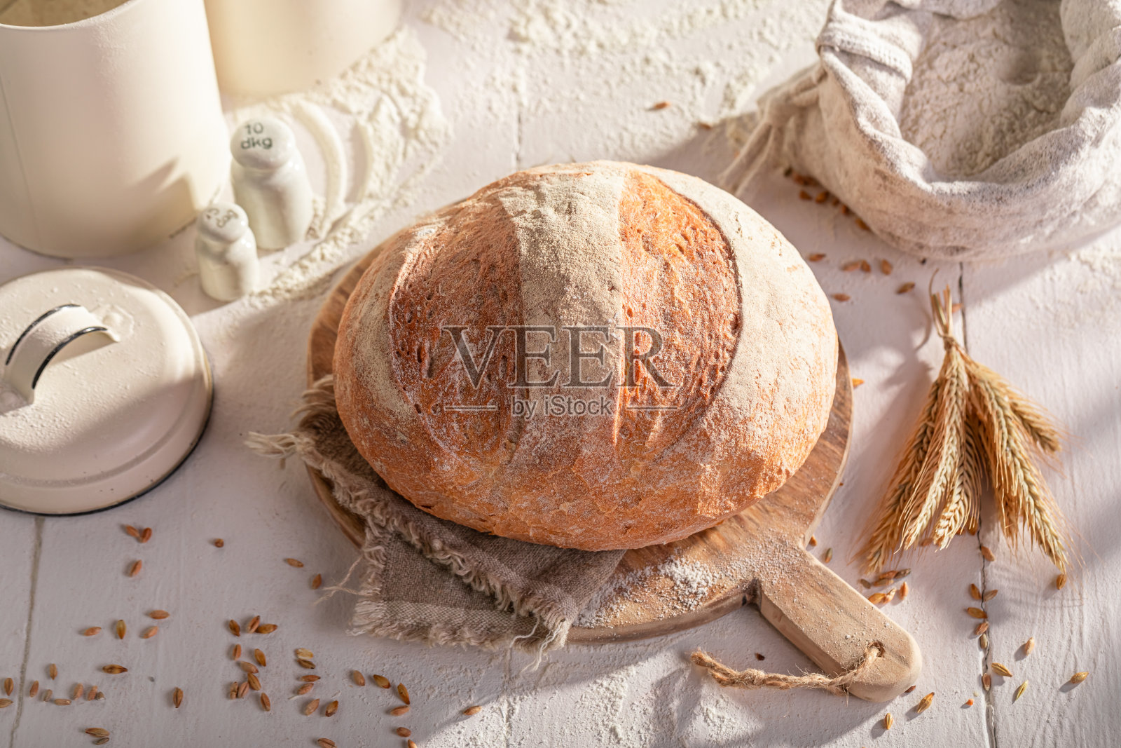 用谷物和麦穗烘烤的美味圆面包。照片摄影图片