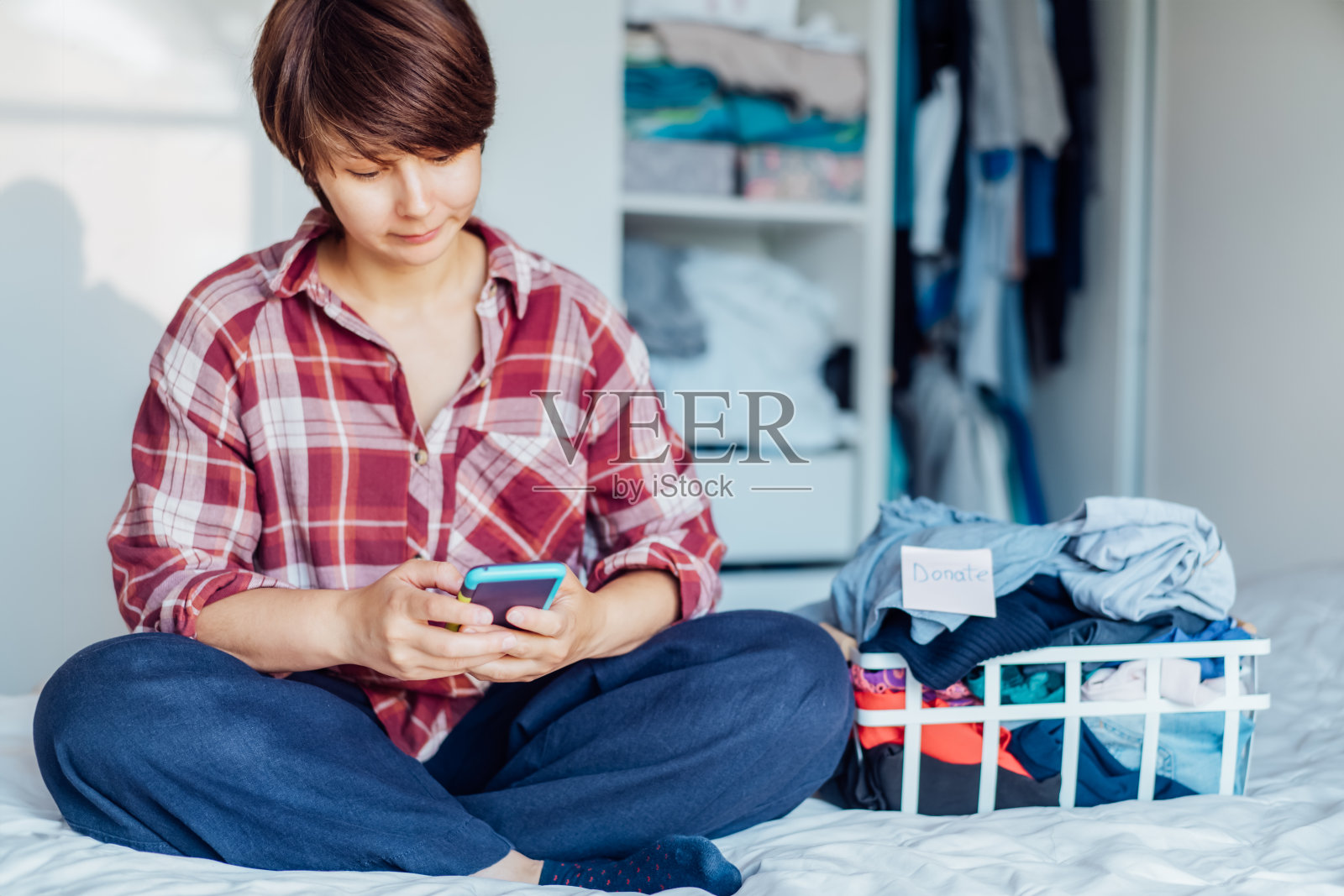 女人手机查询旧衣回收与可持续消费照片摄影图片