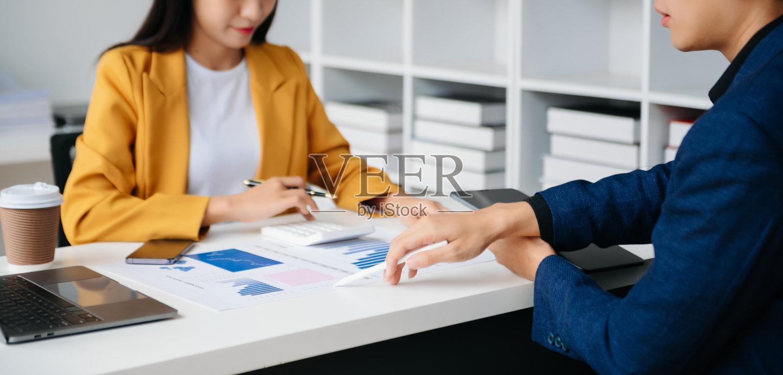 亚洲商务同事商务演示和解释,并使用笔记本电脑和平板电脑。团队合作,金融营销团队,坐在现代化的办公室内。照片摄影图片