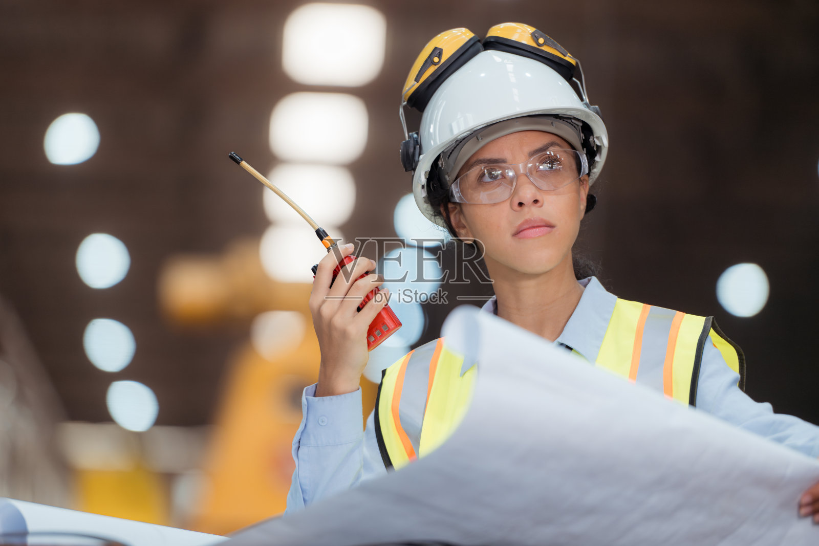 穿着安全背心和安全帽的铁路技术工人在火车维修站按图纸工作的照片照片摄影图片