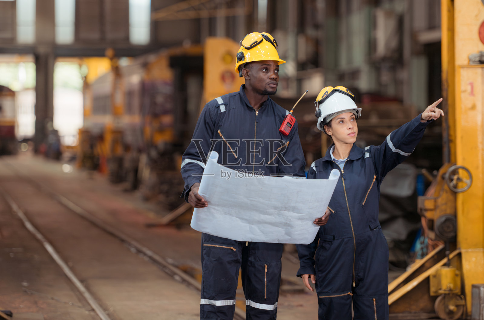 铁路技术人员和工程师在火车维修站检查火车,然后用来拖火车车厢接收或运输货物和人员。照片摄影图片