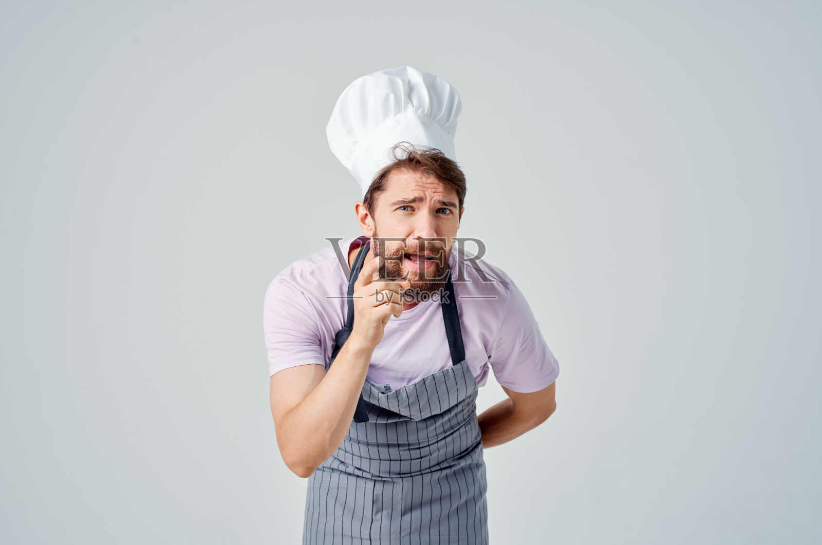 一个人穿着厨师的制服,情绪激动地在厨房里工作照片摄影图片