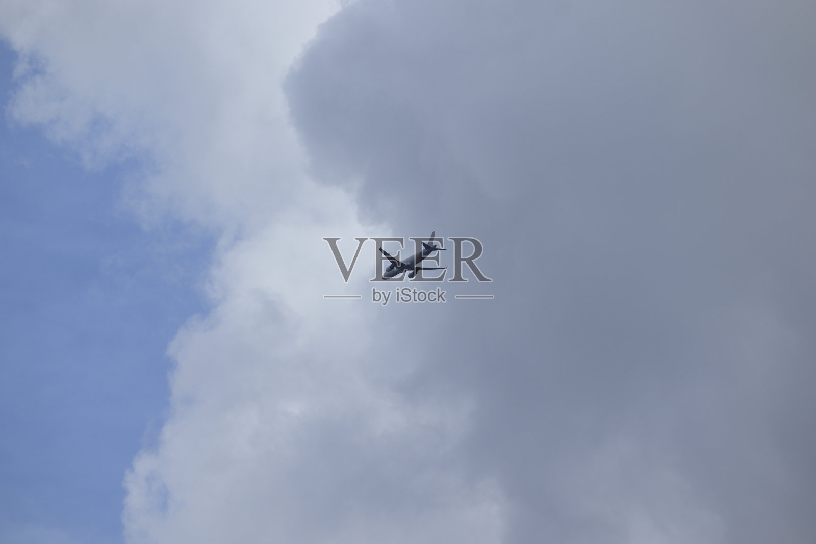 喷气式飞机在高空飞行,开始穿越大片积云。照片摄影图片