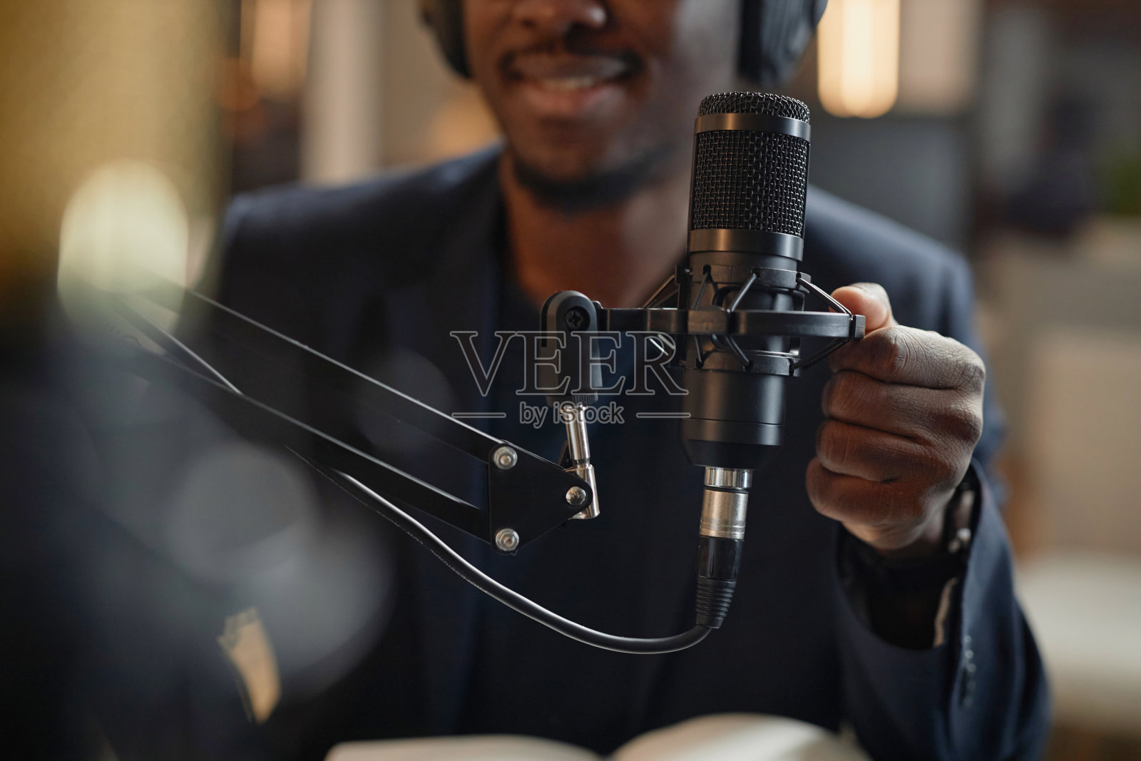 男子在播客期间调整演播室麦克风照片摄影图片