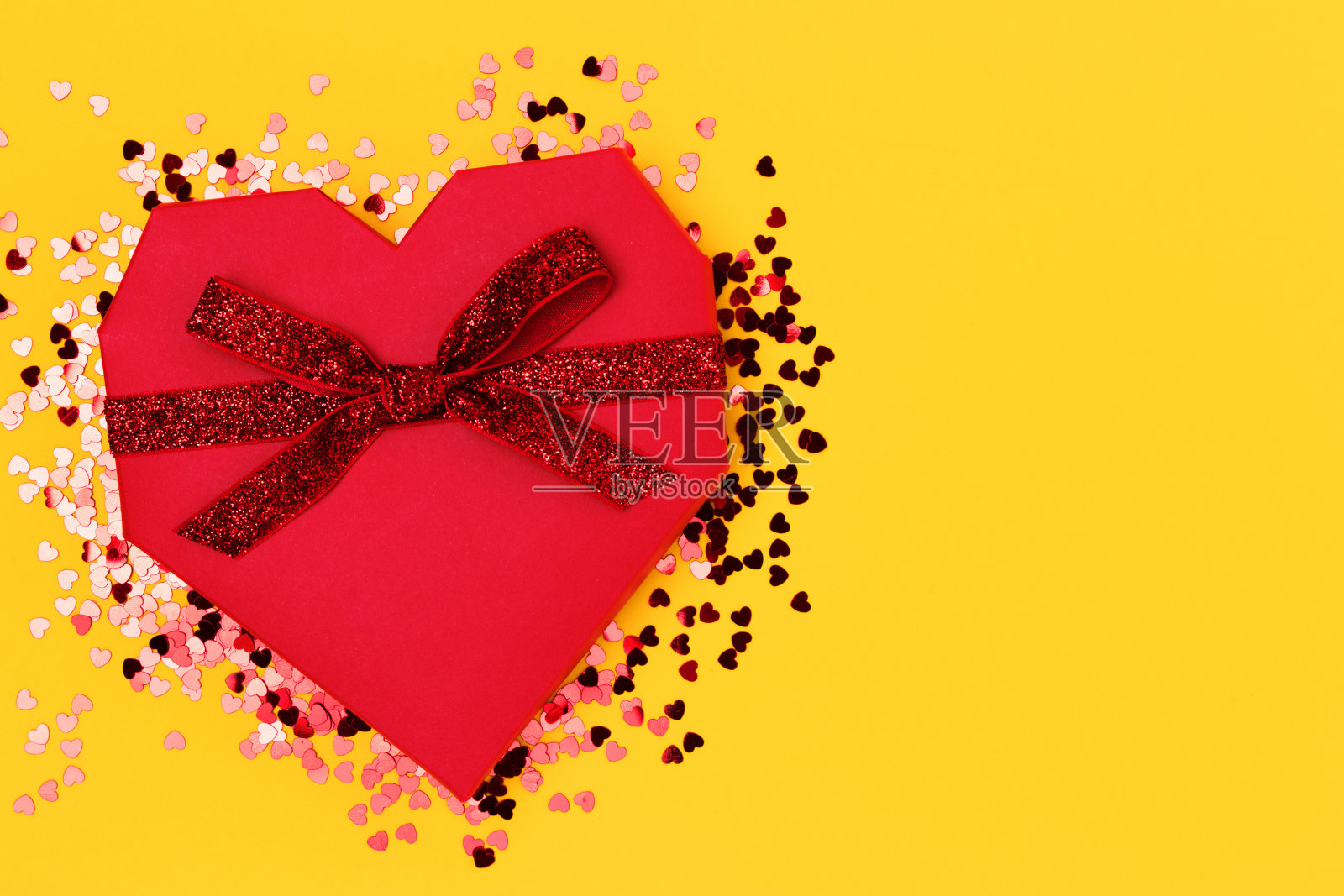 红色的心形礼盒,用闪闪发光的丝带系着。照片摄影图片