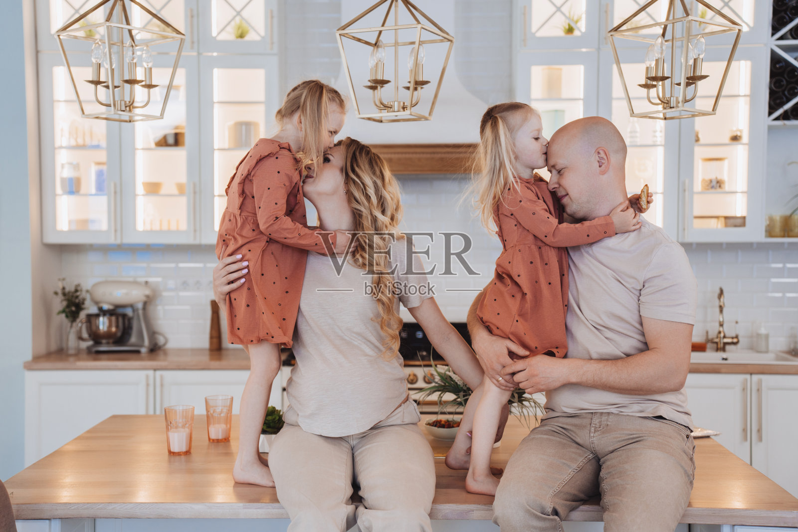 一家人在厨房里深情接吻。照片摄影图片