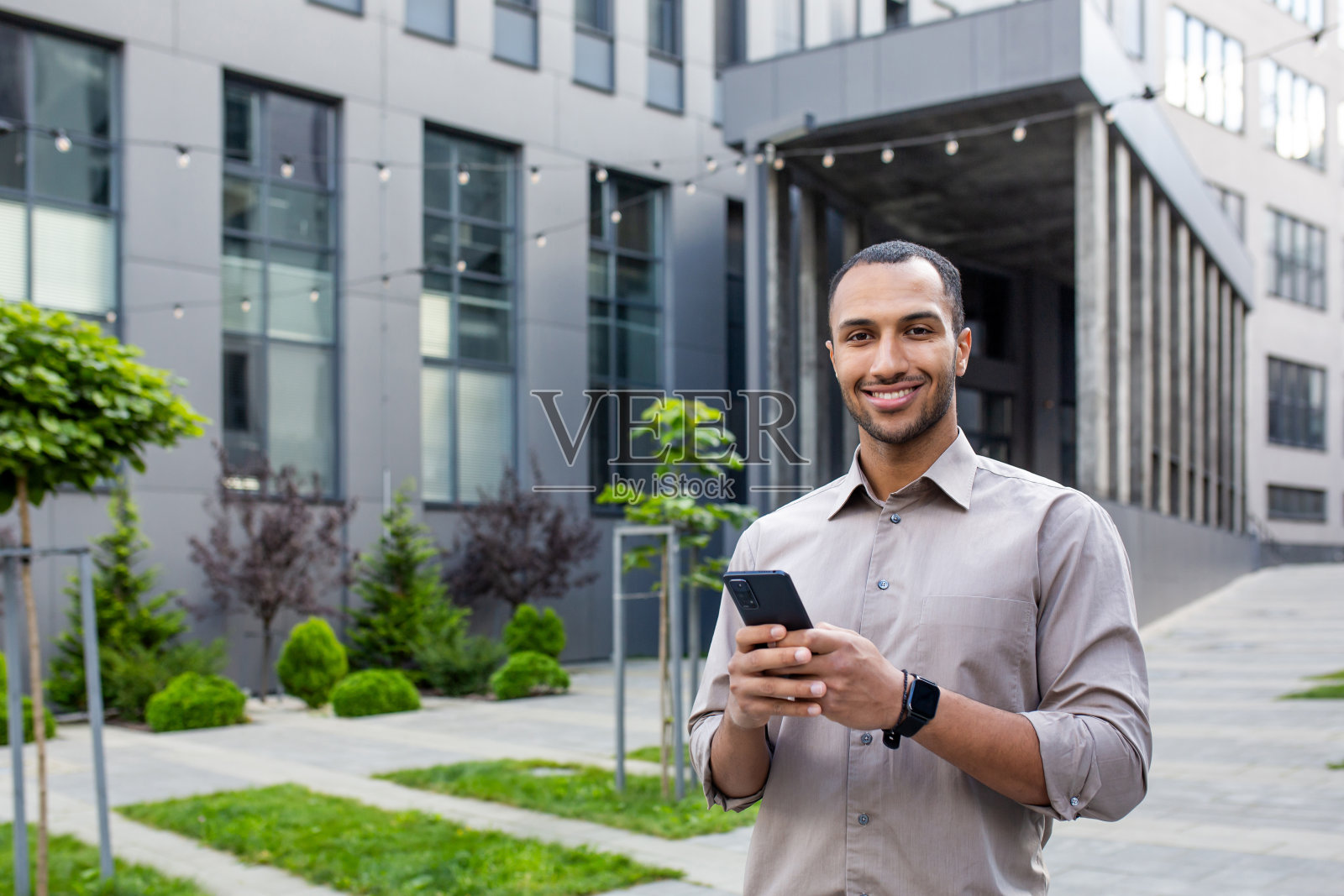 在城市户外使用手机的年轻商人照片摄影图片