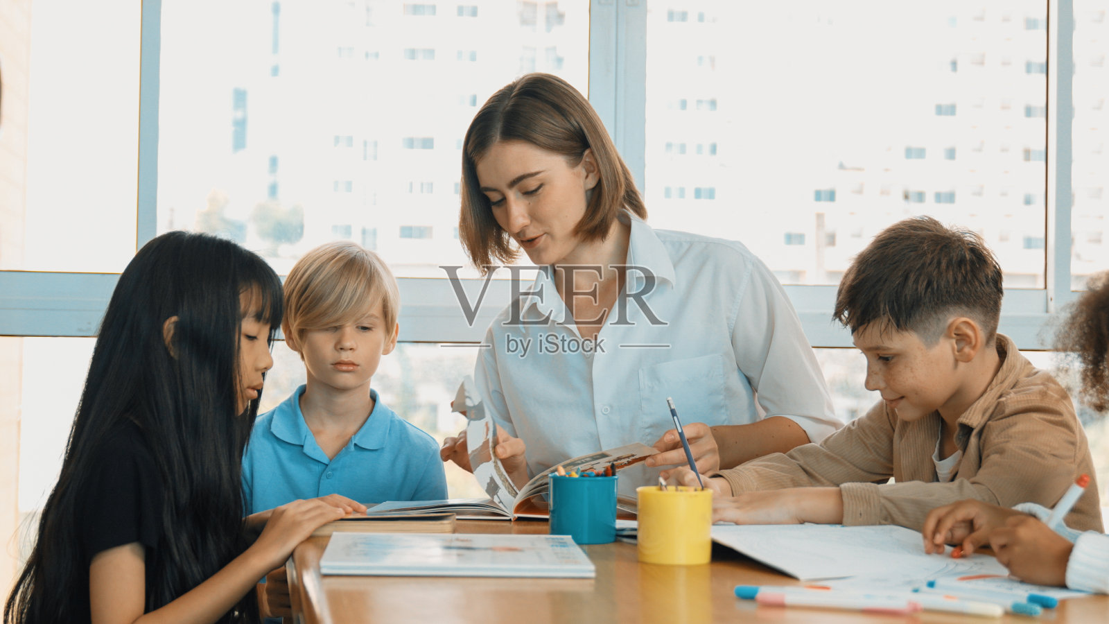 专业的白人老师给不同的学生讲故事。博学。照片摄影图片