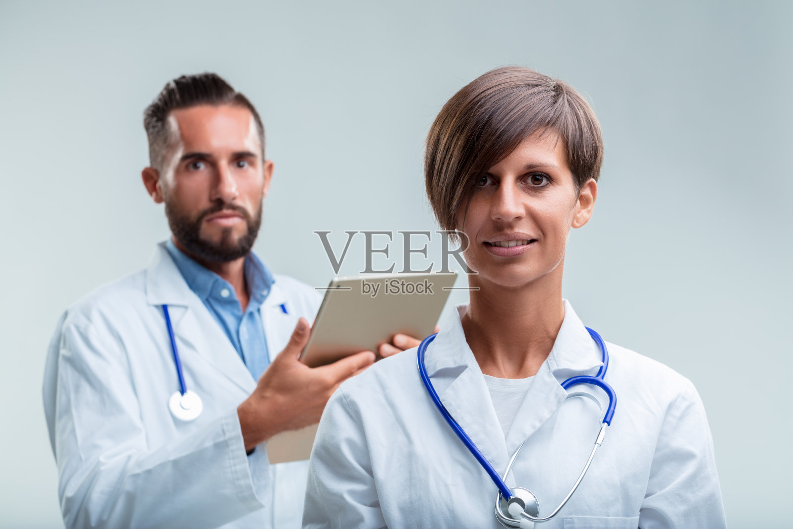 女人发号施令,男人拿着平板电脑提供支持照片摄影图片