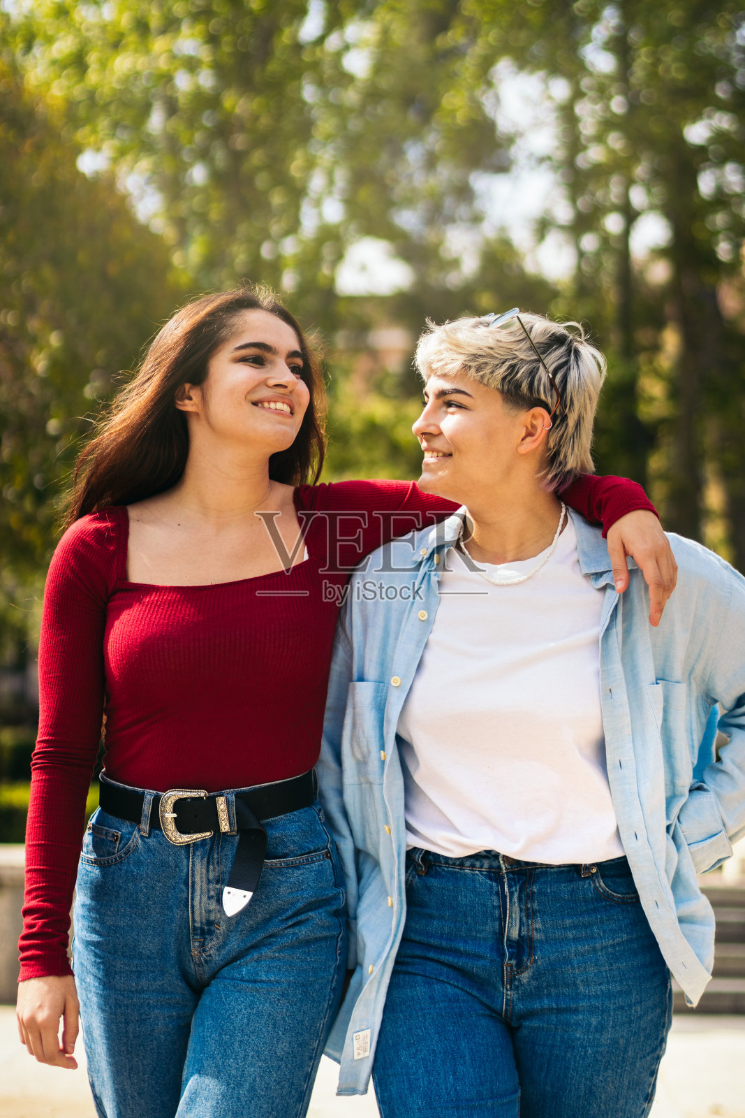 两个小女孩在公园里微笑着散步照片摄影图片