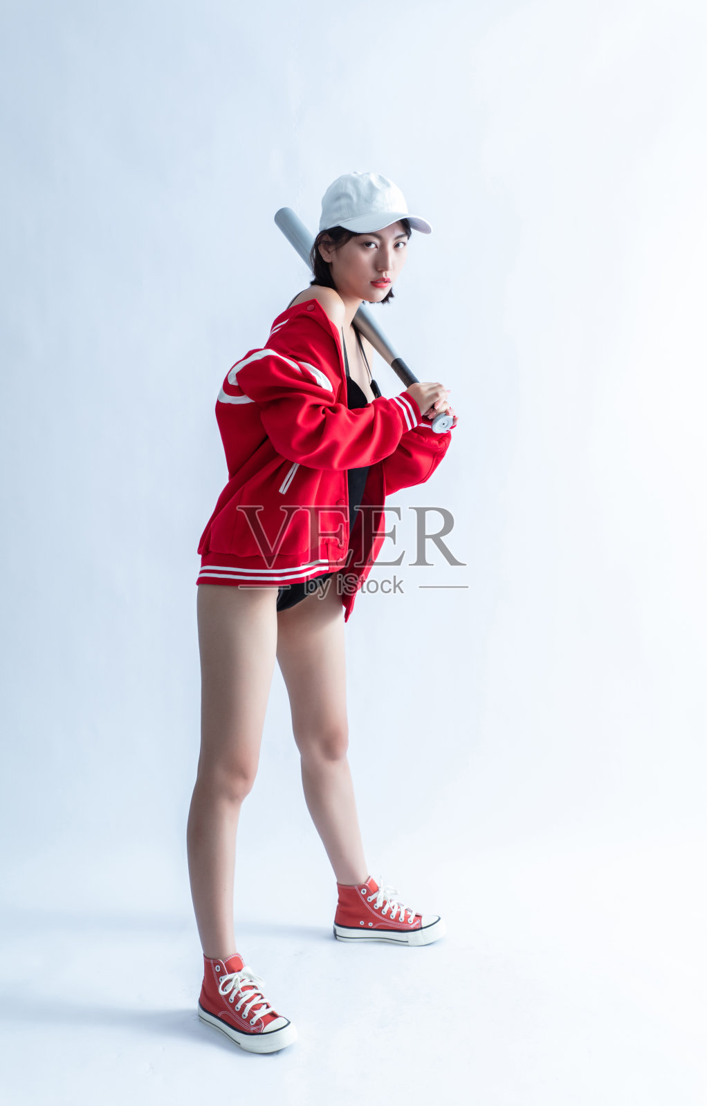 年轻的成年人的肖像迷人和性感漂亮的黑发拉拉队长女孩在黑色内衣和红色棒球夹克孤立的白色背景照片摄影图片