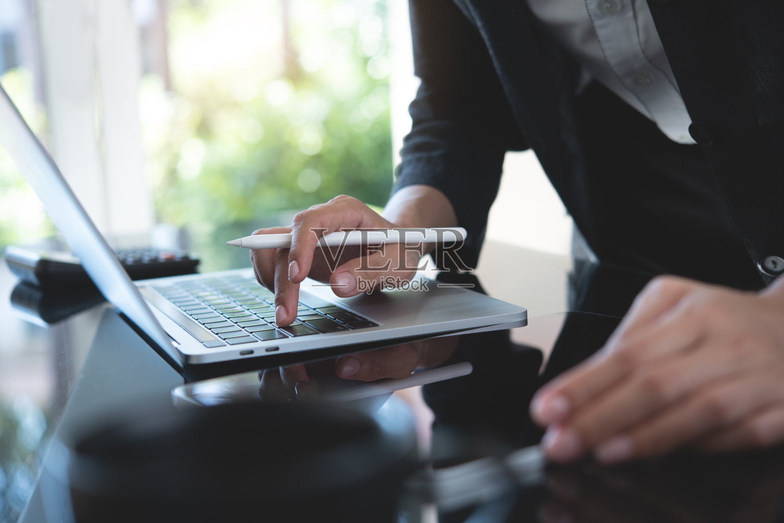 商务女性,项目经理忙于在笔记本电脑上工作,在现代办公室使用数字平板电脑规划工作项目。商务女性用笔记本电脑搜索、分析商业数据、上网照片摄影图片