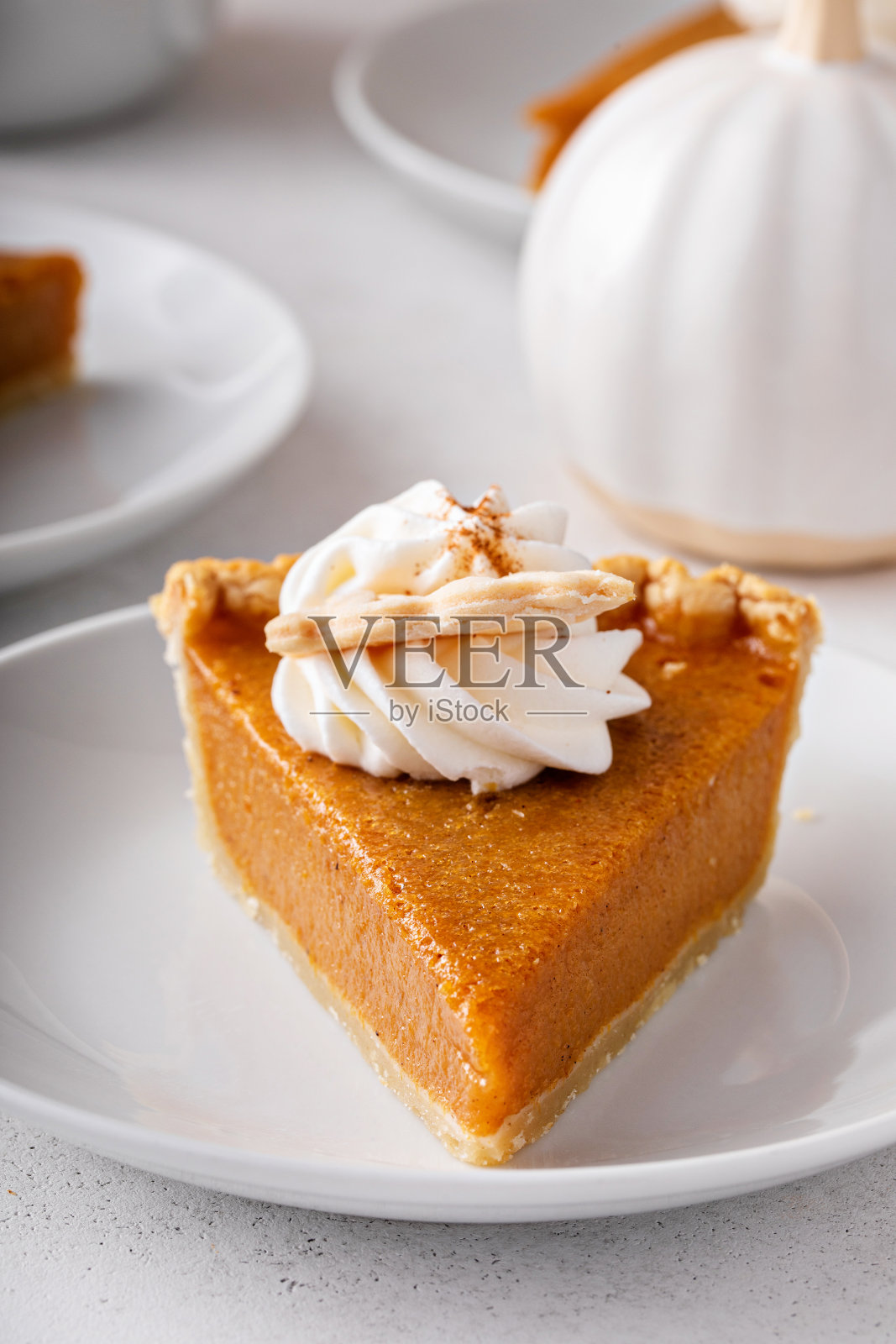 一片传统的感恩节南瓜派,上面淋上鲜奶油照片摄影图片