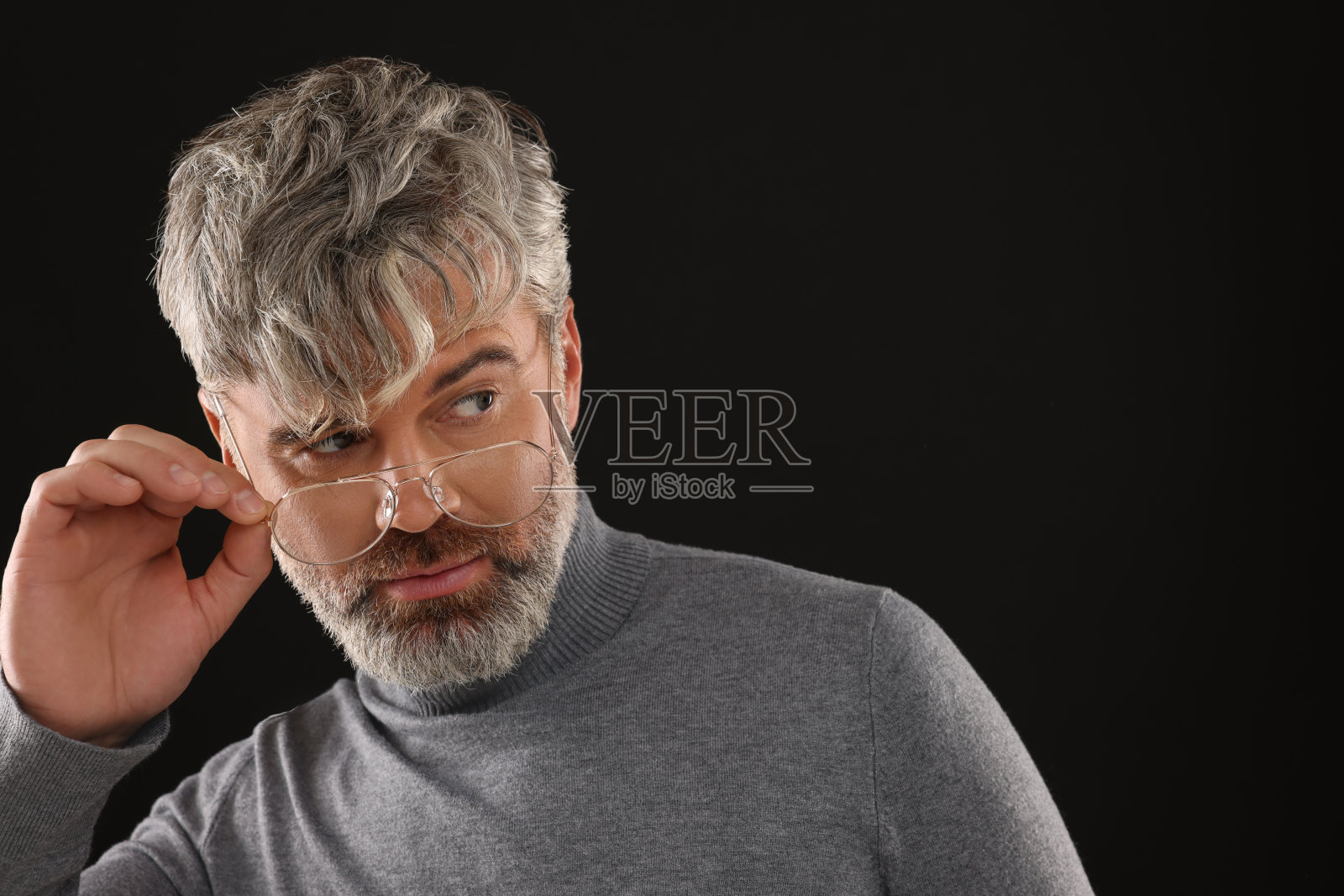 自信的男人的肖像与美丽的发型在黑色的背景。文本空间照片摄影图片